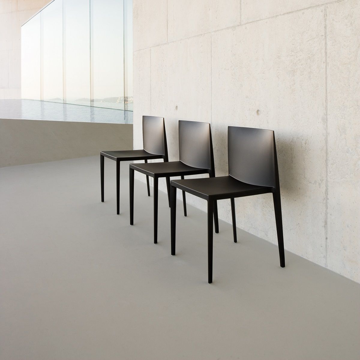 Drei schwarze Sail Stühle SI1245 von Andreu World, stapelbare Designstühle für moderne Innenräume.