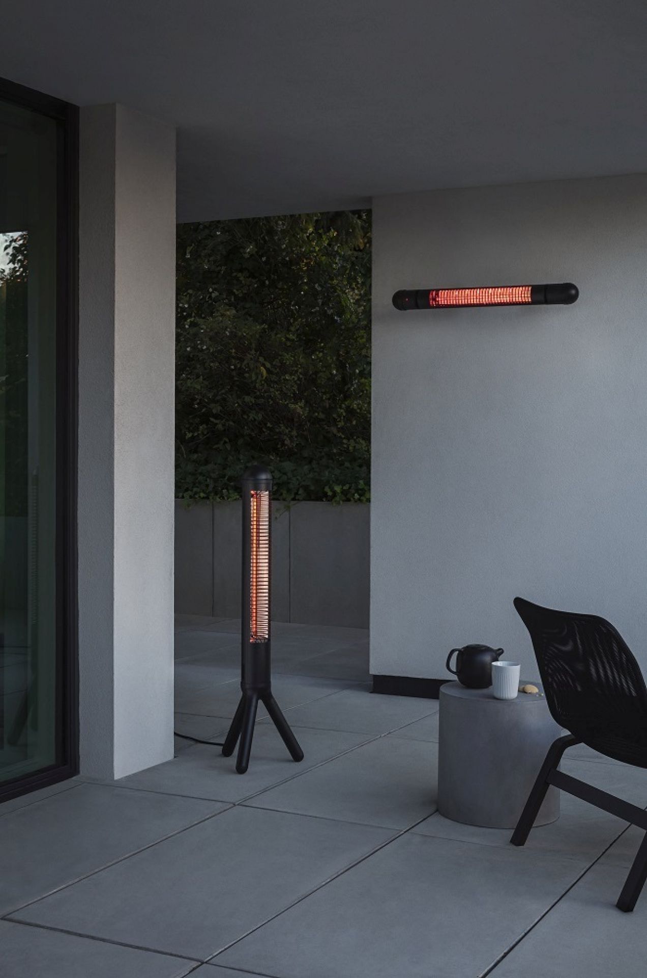 Eva Solo HeatUp Wand-Terrassenwärmer und Stand-Heizstrahler auf einer Terrasse mit Möbeln.