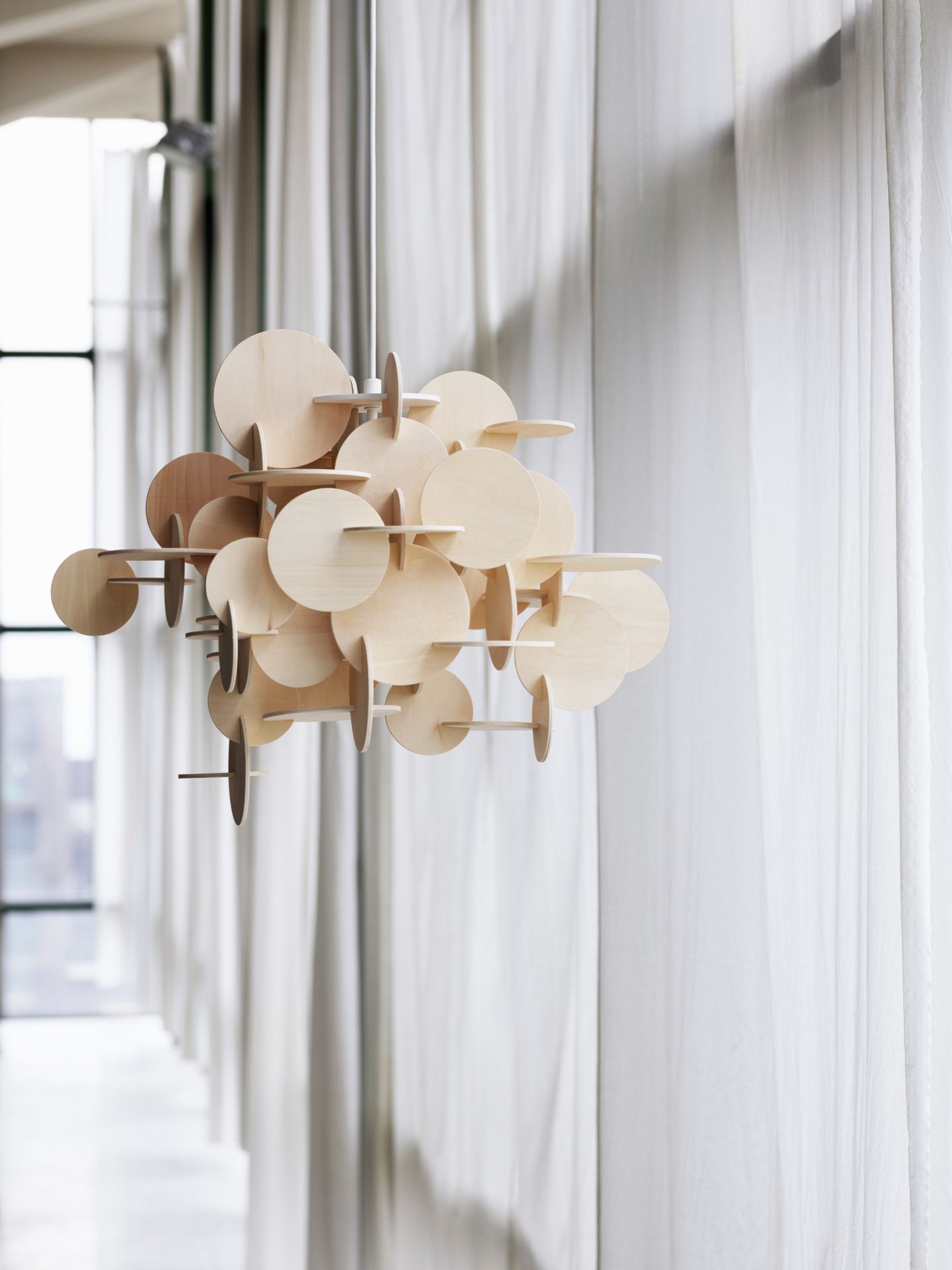Normann Copenhagen Bau Pendelleuchte aus Holz, moderne Hängelampe mit runden Elementen im Innenraum.