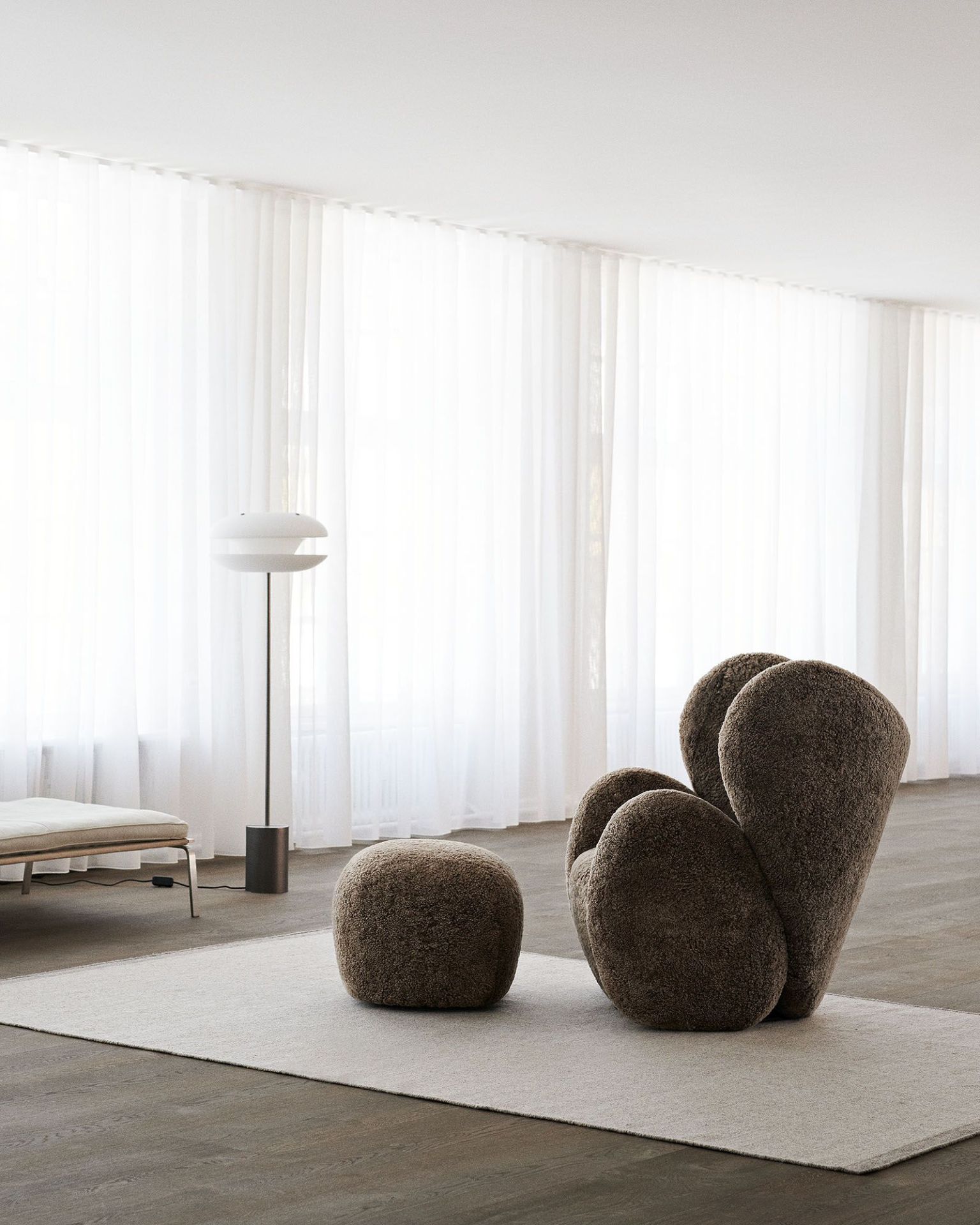 Big Big Lounge Chair Sessel von NORR11 mit passendem Hocker in modernem Wohnzimmer mit Teppich.