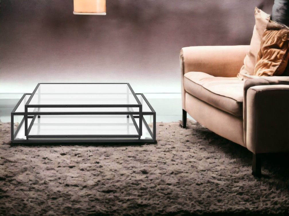 Moderner Tangled Square Couchtisch Spectrum mit Glasplatte und schwarzem Metallrahmen neben beigem Sofa.