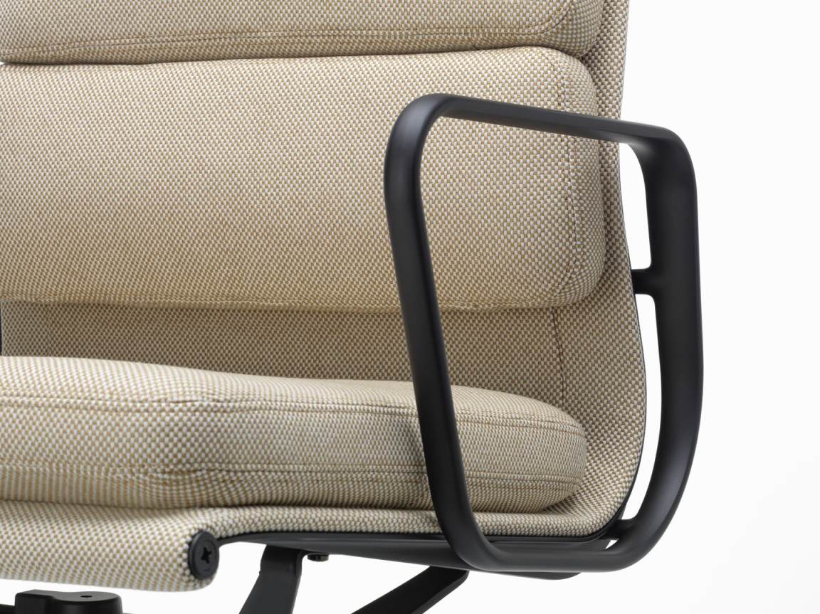 Detailaufnahme des Vitra Soft Pad Chair EA 231 mit beigem Stoffbezug und schwarzen Armlehnen.