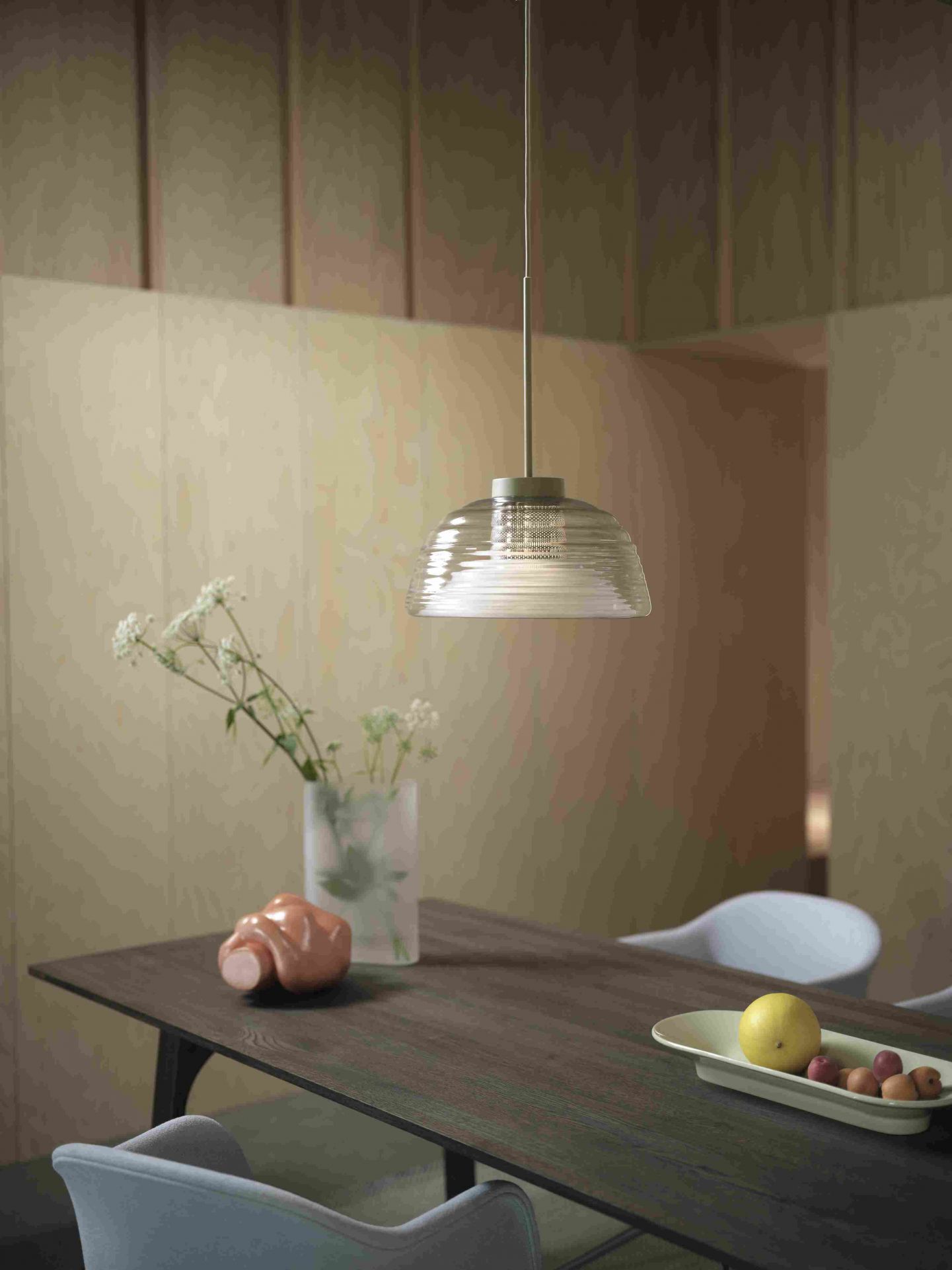 Muuto Two-Layer Pendelleuchte aus Glas über Esstisch mit Dekoration, modernes skandinavisches Design.