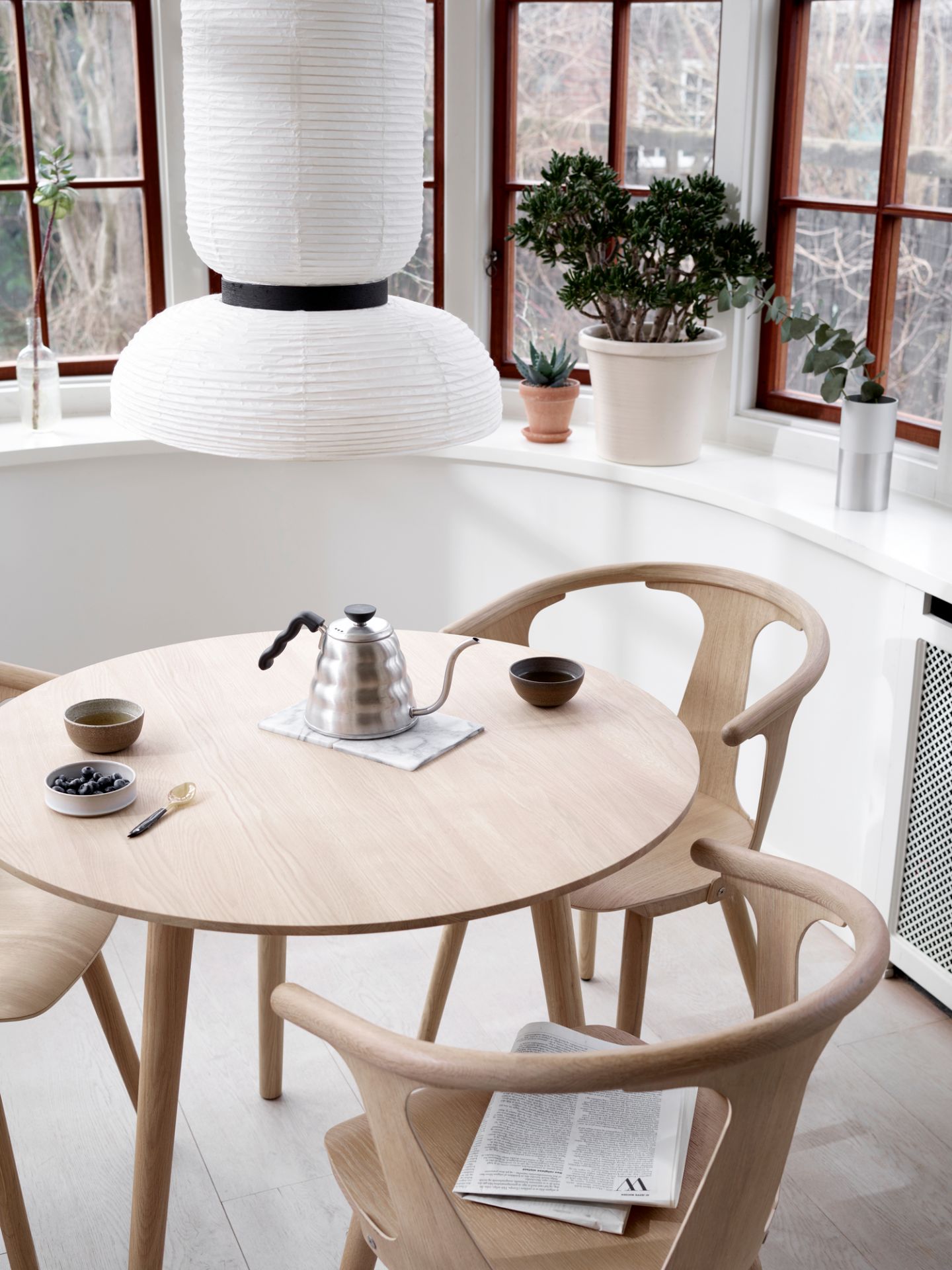 Esszimmer mit rundem Holztisch und drei In Between Chair Stühlen von AndTradition aus Eiche.