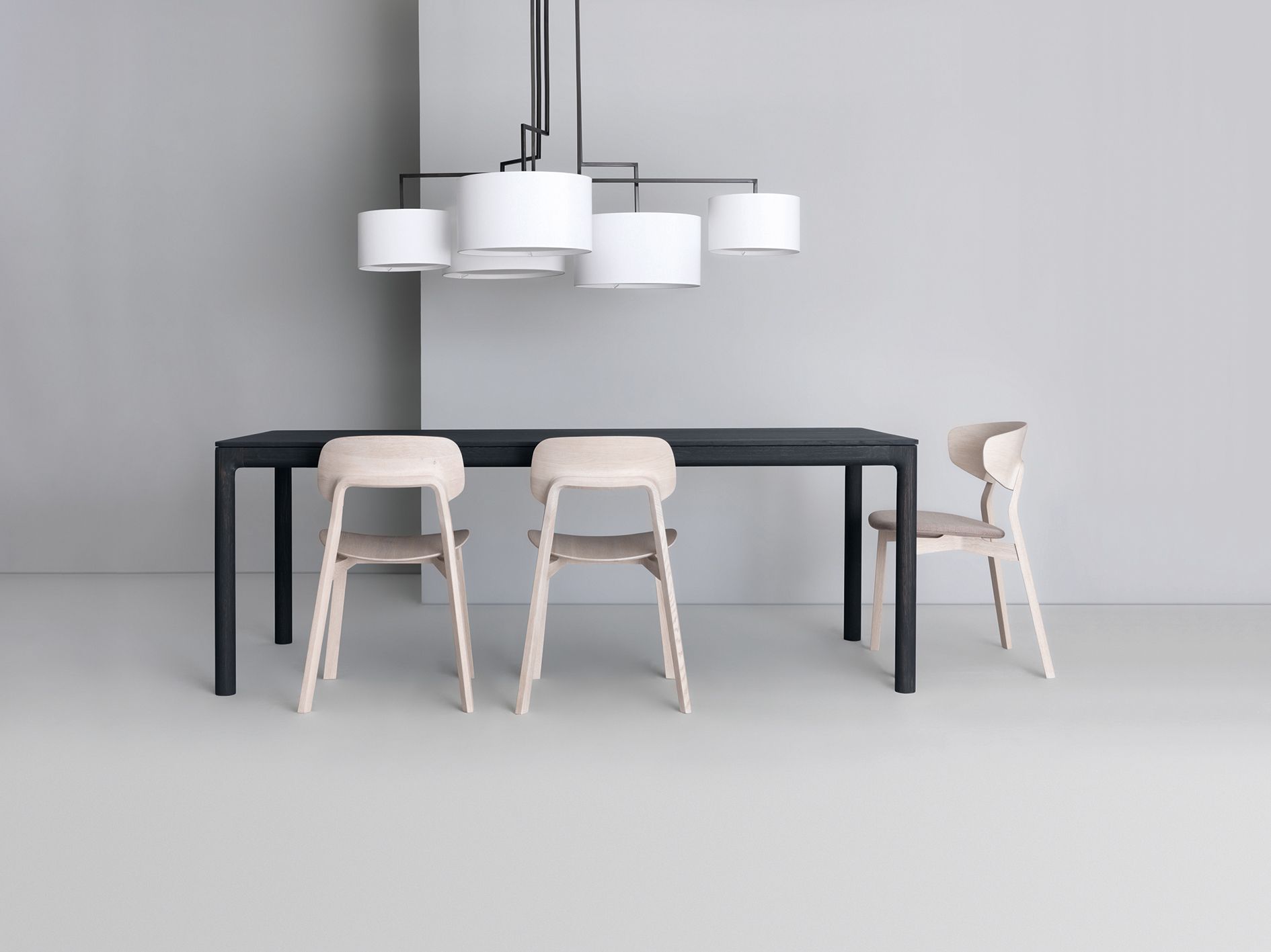M11 Tisch Massivholz Zeitraum mit Stühlen und moderner Lampe im minimalistischen Esszimmer.