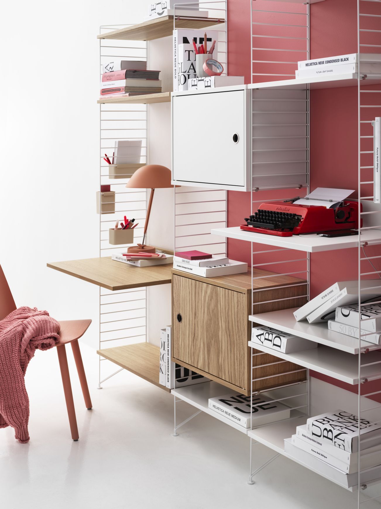 Detailaufnahme eines String Furniture Regals mit Schwenktür, Schreibtischplatte und Bücherregalen.