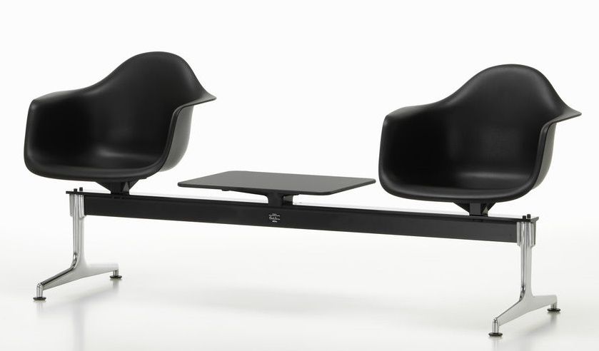 Schwarze Eames Plastic Armchairs auf Traverse von Vitra mit Ablagetisch, modernes Wartezimmer-Design.