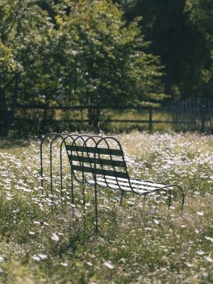 Gardener's Sofa von Design House Stockholm im Freien, umgeben von Gänseblümchen. Outdoor Sofa aus Metall.