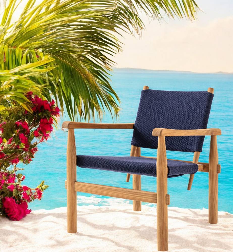 Cassina Doron Sessel für den Außenbereich mit blauem Stoffbezug und Holzgestell am Strand.