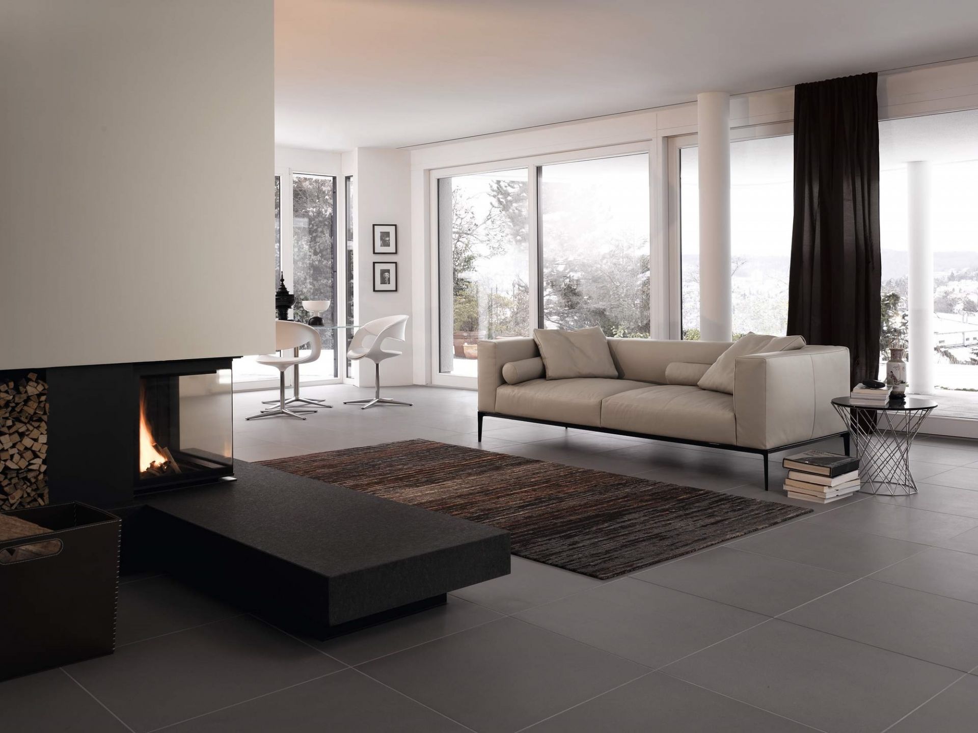 Helles Wohnzimmer mit Walter Knoll Sofa, Teppich, Kamin und großen Fenstern für viel Tageslicht.