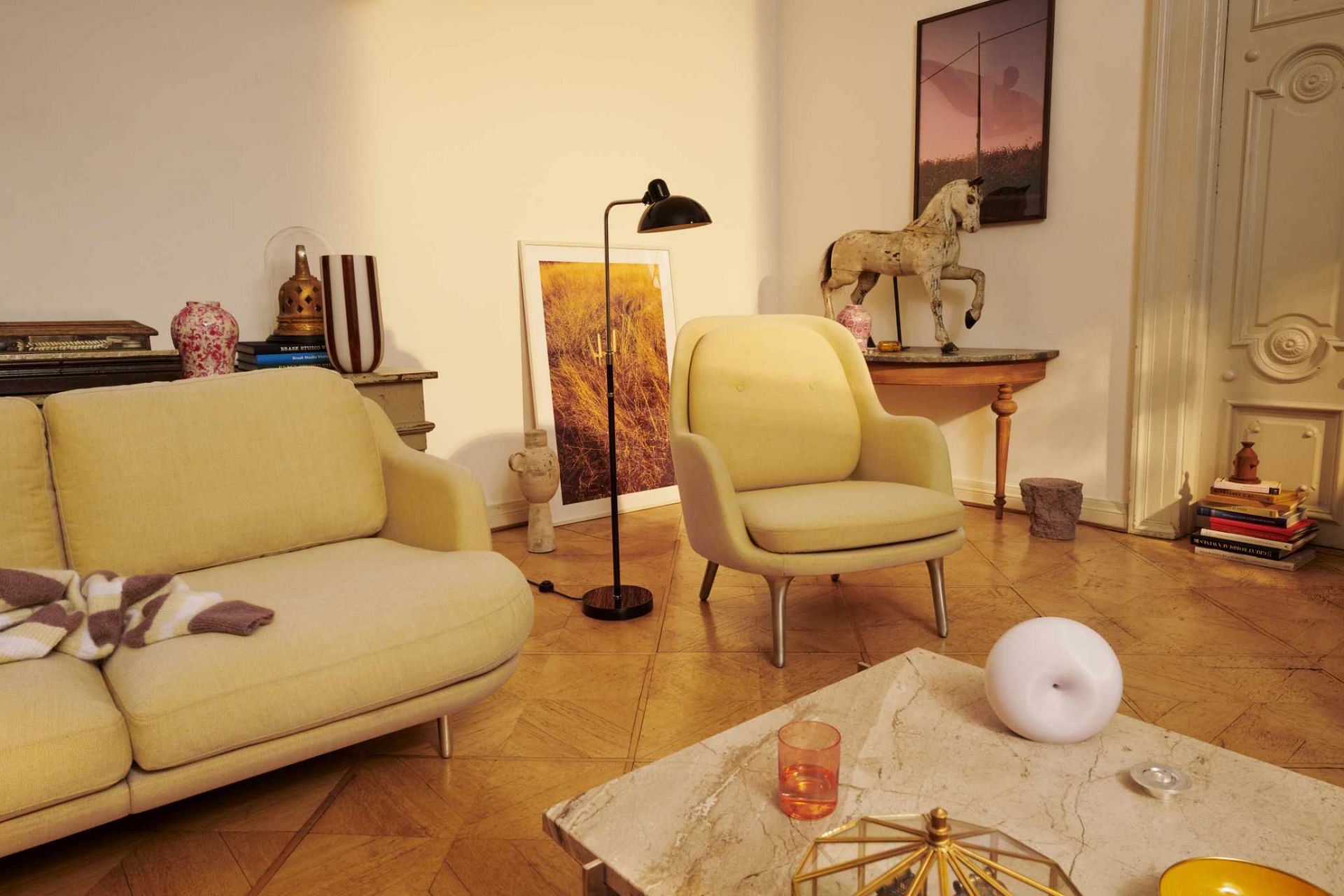 Heller Fri Sessel von Fritz Hansen in einem Wohnzimmer mit Sofa und Dekoration.