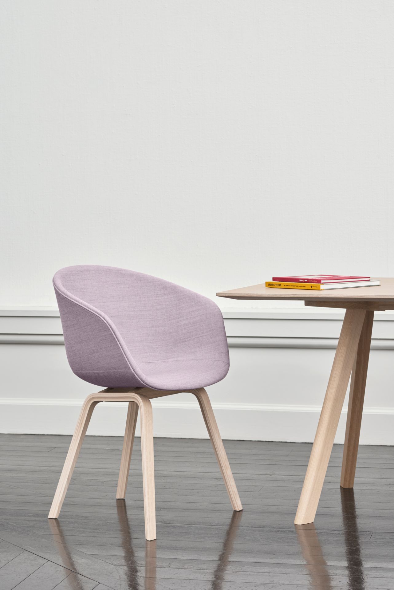 About A Chair AAC23 Stuhl von Hay mit lila Polsterung und hellem Holzgestell neben Holztisch.