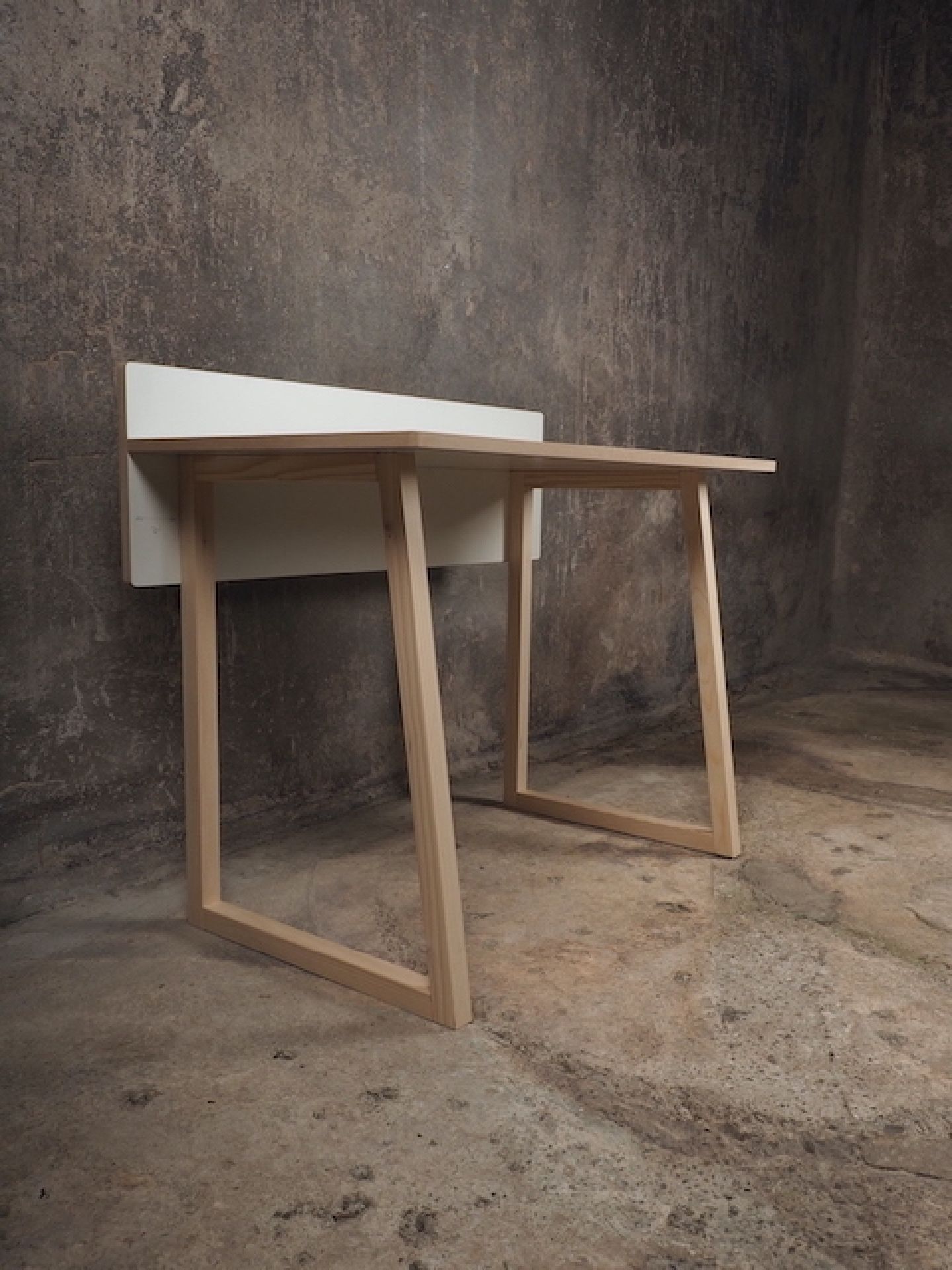 Tojo Kids Werk Schreibtisch aus Holz mit weißer Platte vor einer grauen Wand.