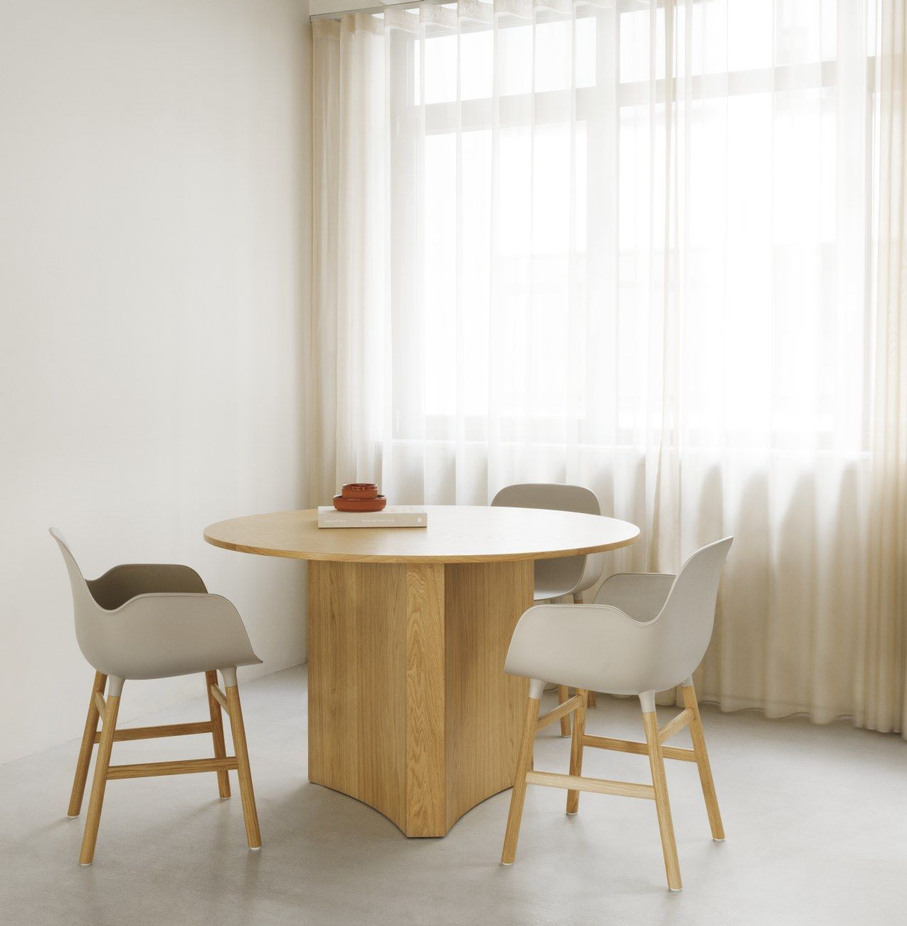 Bue Table Esstisch von Normann Copenhagen mit Stühlen in hellem Raum, Fokus auf Tischdesign.