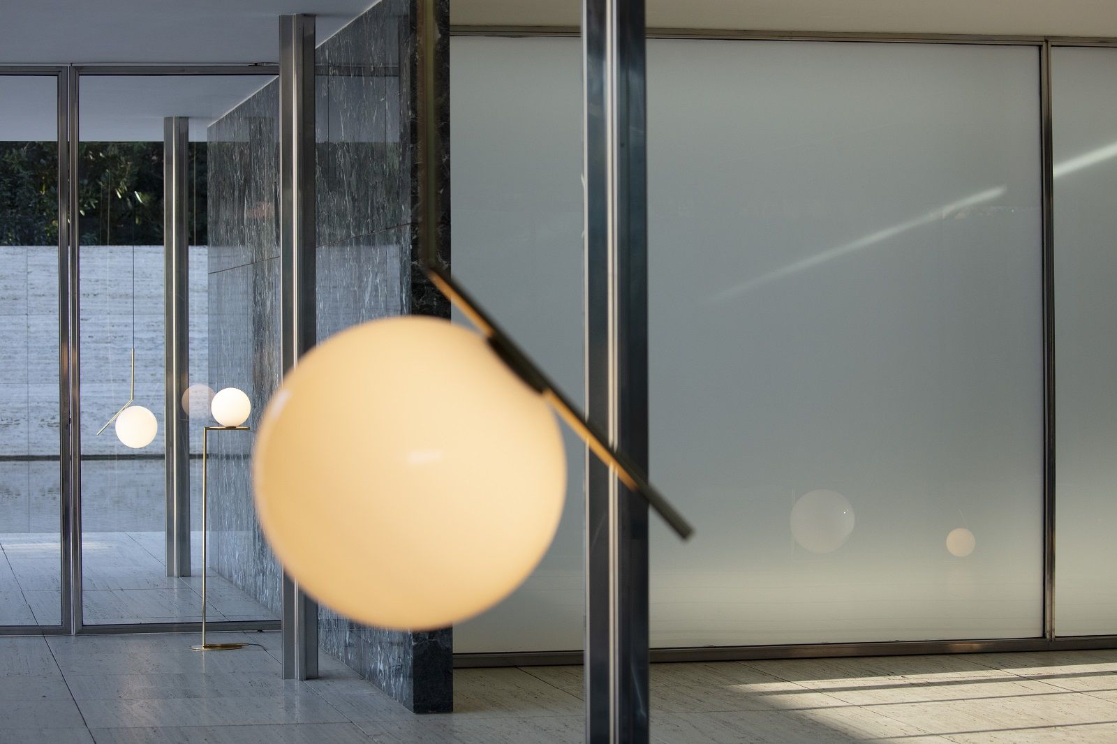 Nahaufnahme der IC F1 Stehleuchte in Gold von Flos, modernes Design mit Kugel-Lampenschirm.
