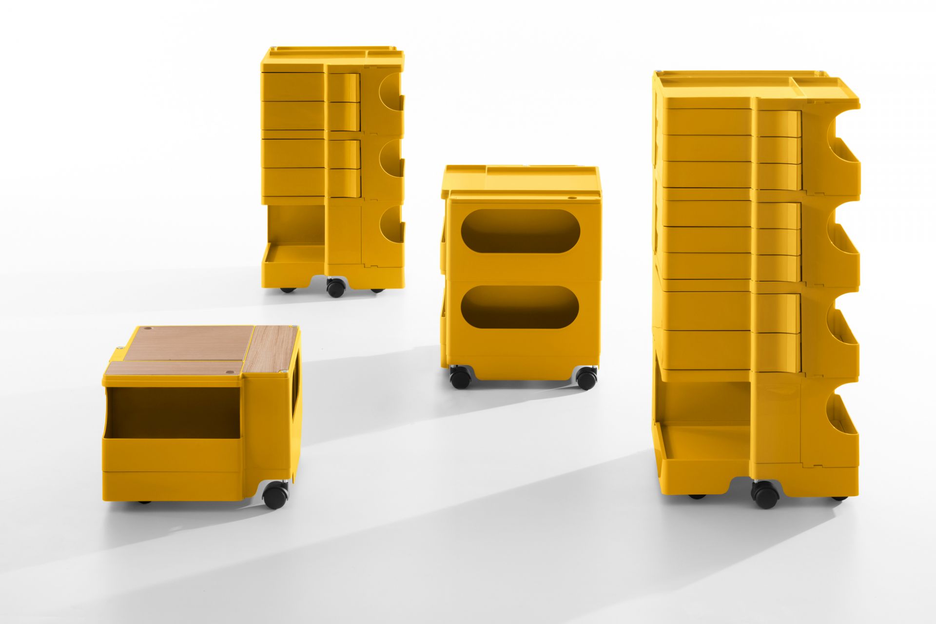 Gelbe Boby B32 Rollcontainer B-Line: Mehrere modulare Aufbewahrungswagen mit Schubladen und Fächern auf Rollen.