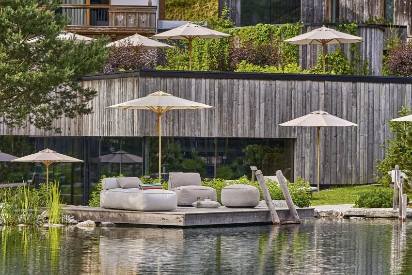 Weishäupl Sonnenschirme: Klassischer Schirm mit Holzständer am Pool für entspannte Sommertage.
