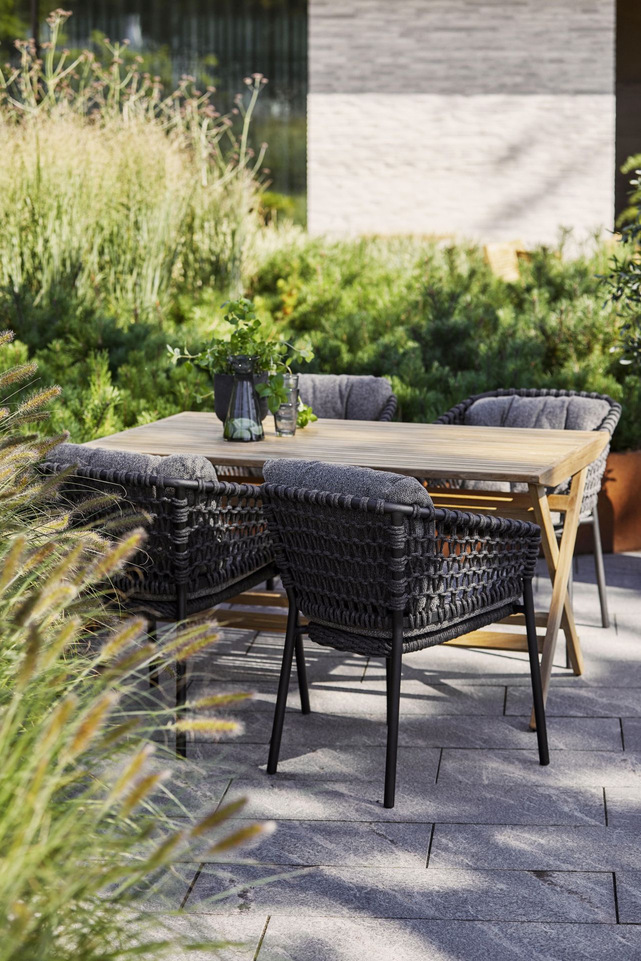 Nahaufnahme von Cane-Line Ocean Lounge Stühlen und Holztisch im Garten, Outdoor Möbel.