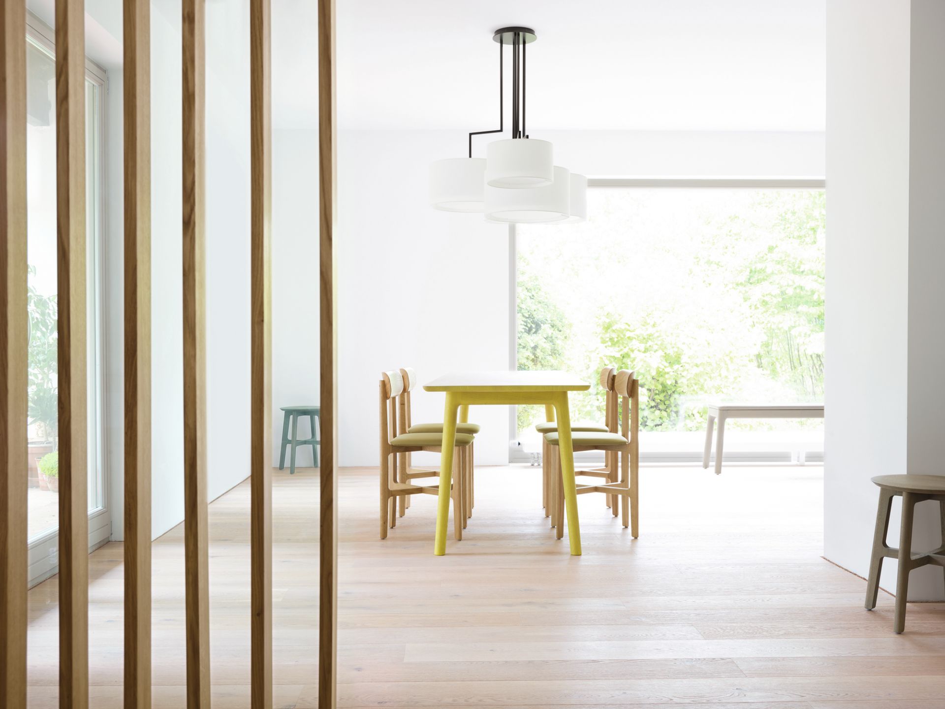 Esszimmer mit 1.3 Chair Holzstühlen von Zeitraum und gelbem Esstisch unter moderner Lampe.