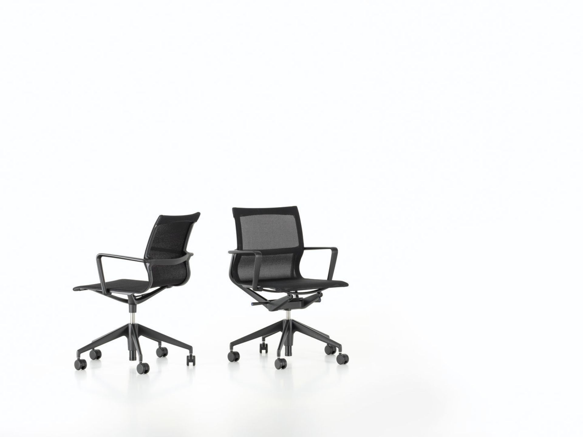 Zwei schwarze Physix Konferenzstühle von Vitra mit Armlehnen und Rollen vor einem weißen Hintergrund.