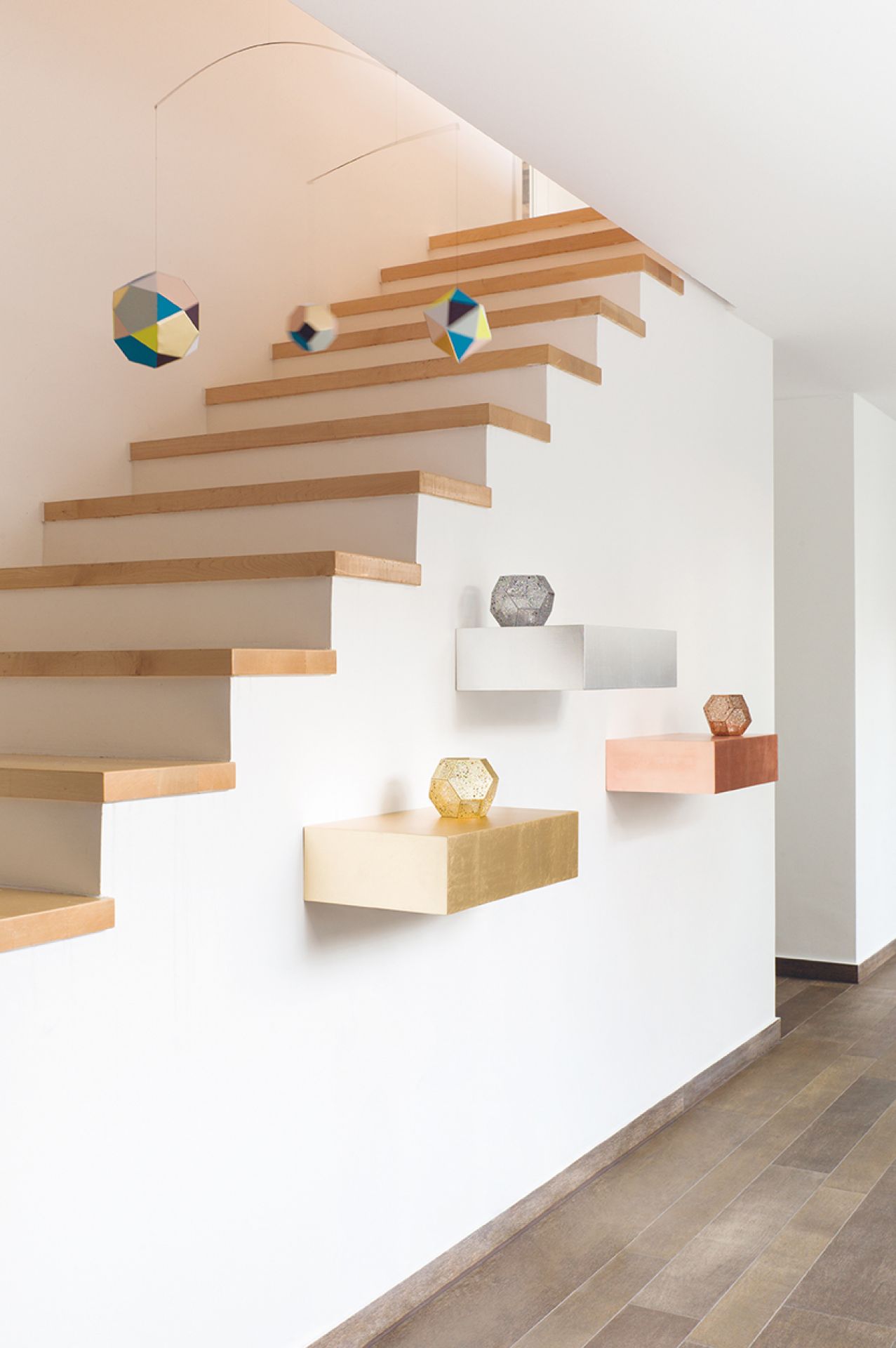 Epoca Schubkastenkonsole von Schönbuch an einer Wand unter einer Treppe. Dekorative Wandkonsole in Gold, Silber und Kupfer.