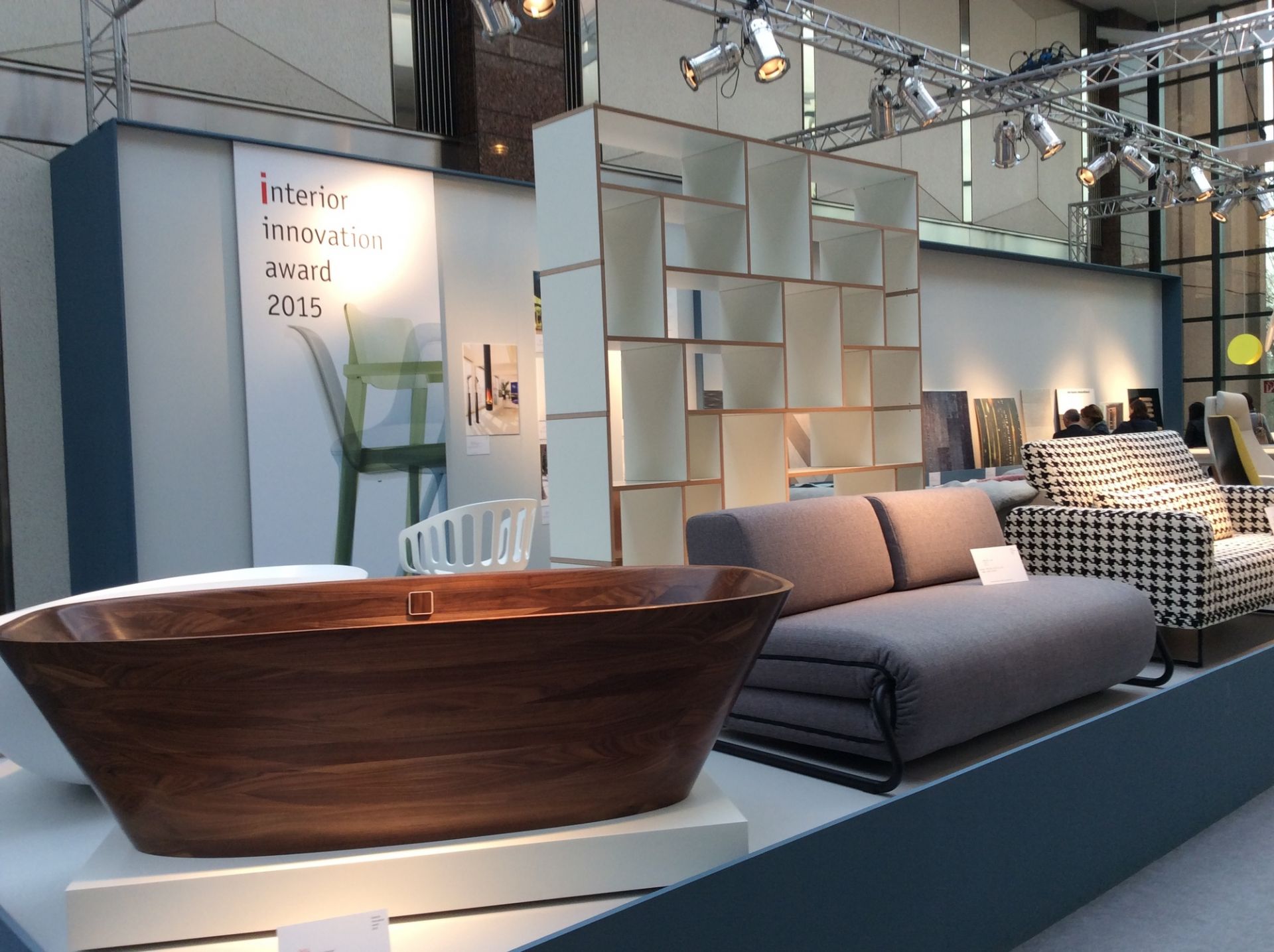 Ausstellungsansicht mit Tojo Hanibal Regal, Badewanne und Sofa, modernes Möbeldesign für Wohnzimmer und Badezimmer.