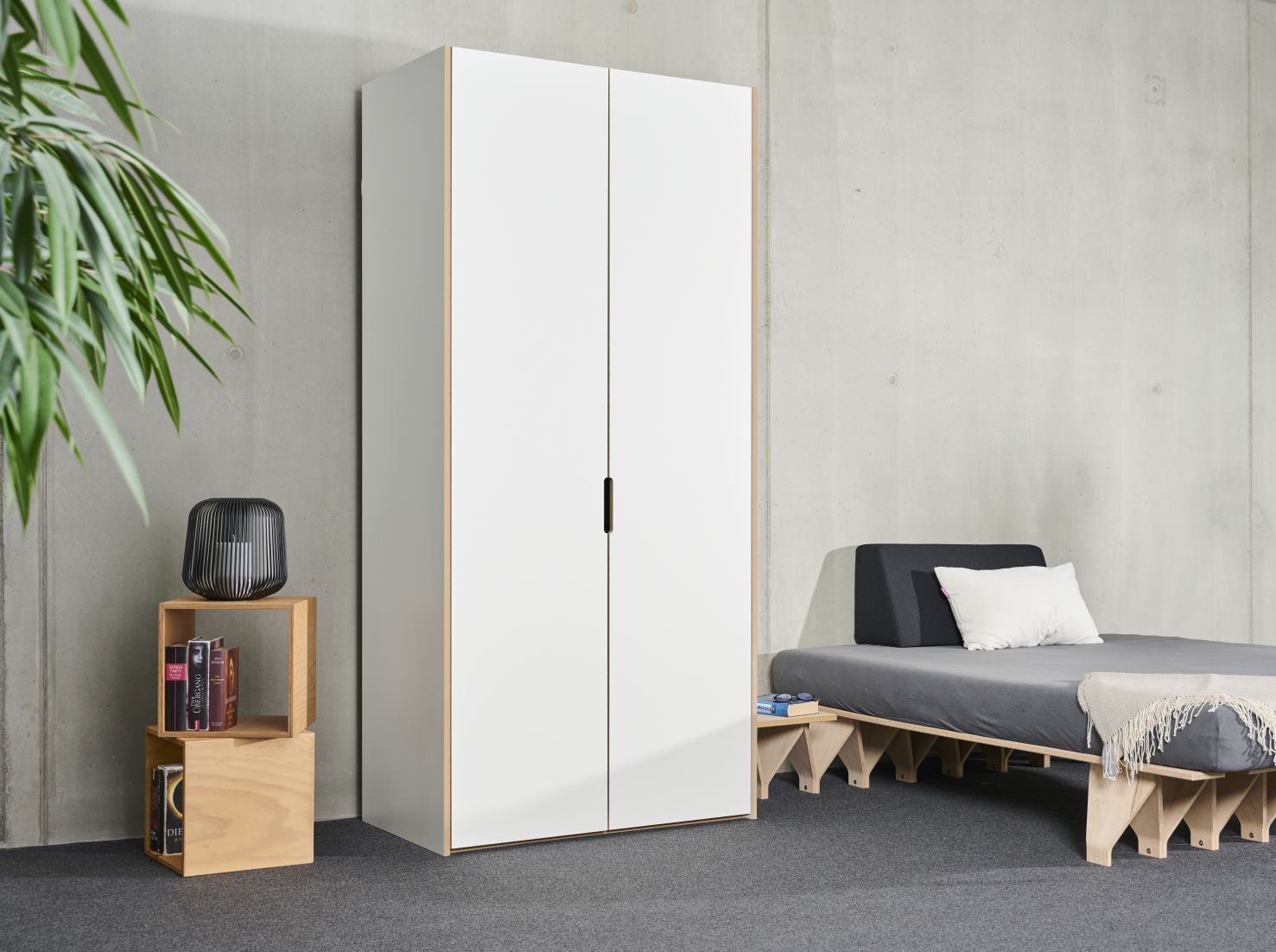 Tojo Schrank Grundmodul: Weißer Kleiderschrank mit zwei Türen im modernen Schlafzimmer.
