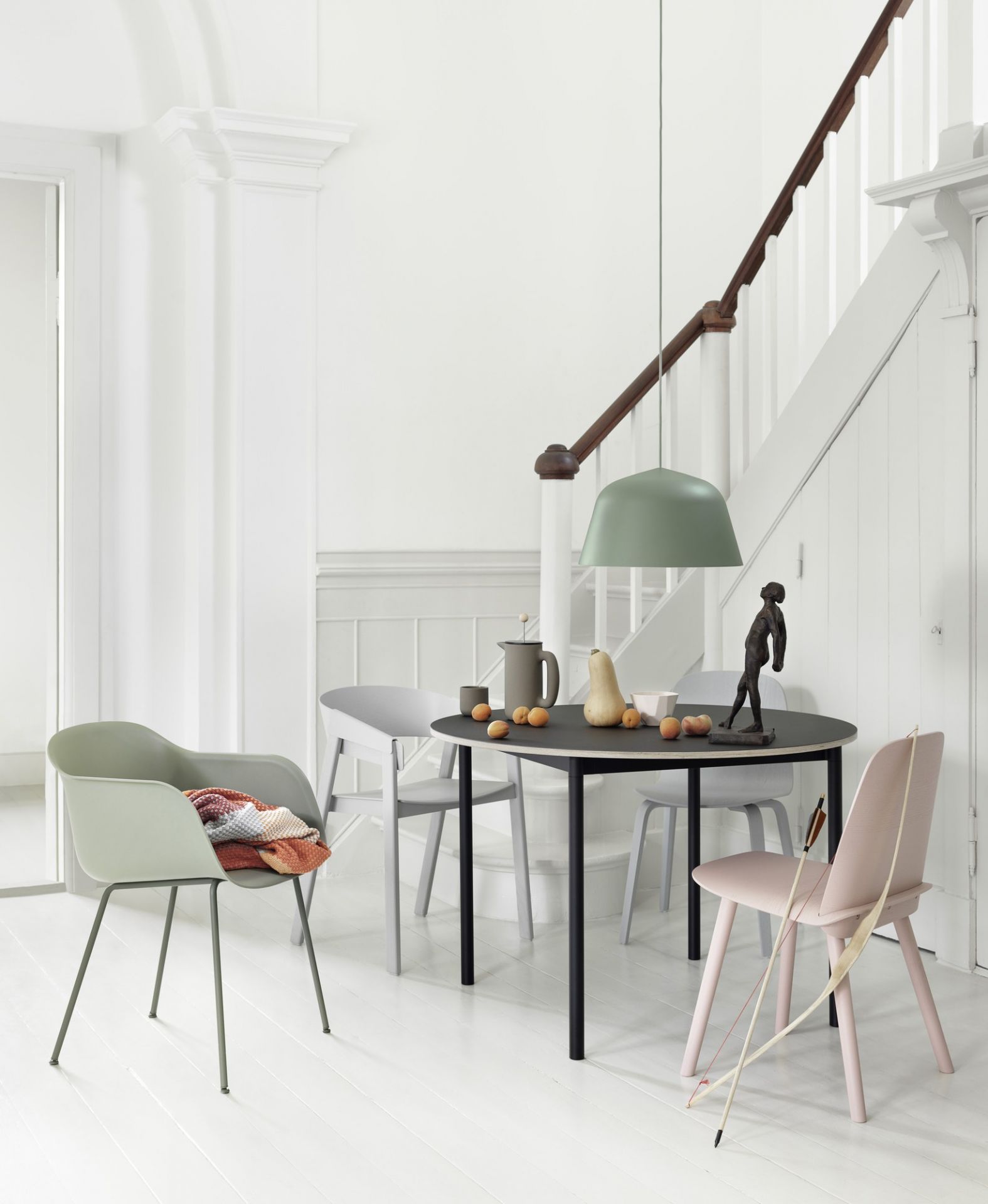 Esszimmer mit Muuto Ambit Pendelleuchte in Grün über schwarzem Esstisch. Modernes Lampendesign.