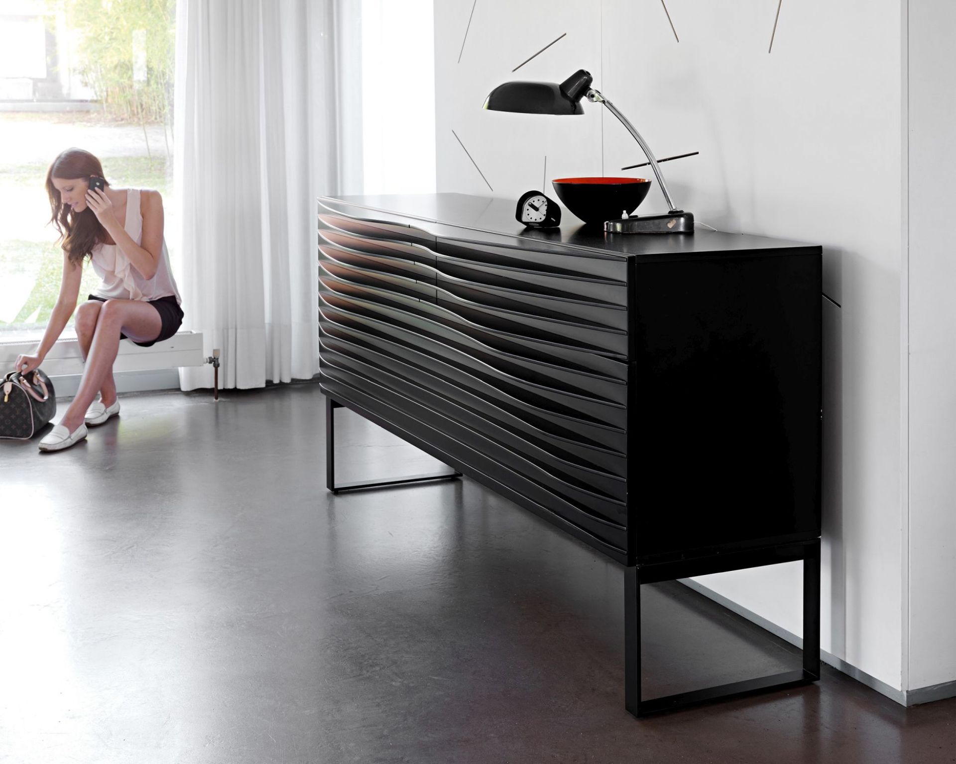 Schwarze Tide Anrichte von Casamania Horm mit minimalistischem Design und schwarzem Gestell im modernen Wohnzimmer.