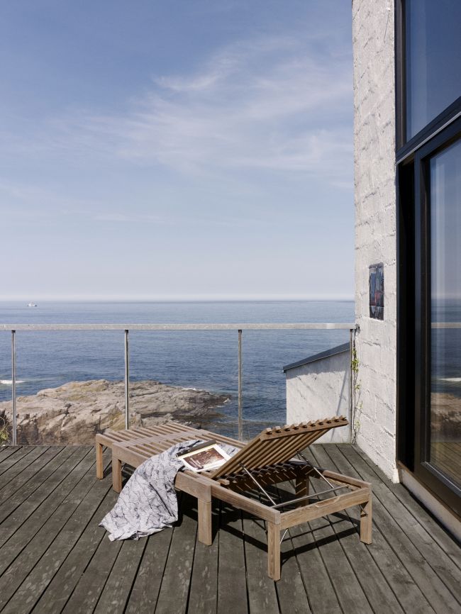 Riviera Sonnenliege aus Holz von Skagerak by Fritz Hansen auf einer Terrasse mit Meerblick.