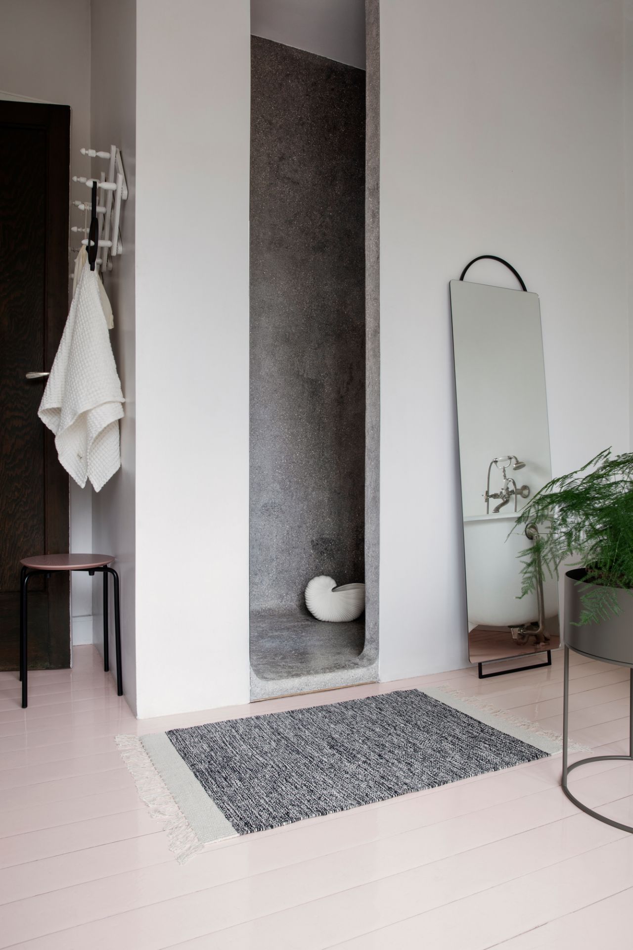 Helles Badezimmer mit Ferm Living Shell Pot Vase als Deko-Element im grauen Duschbereich.