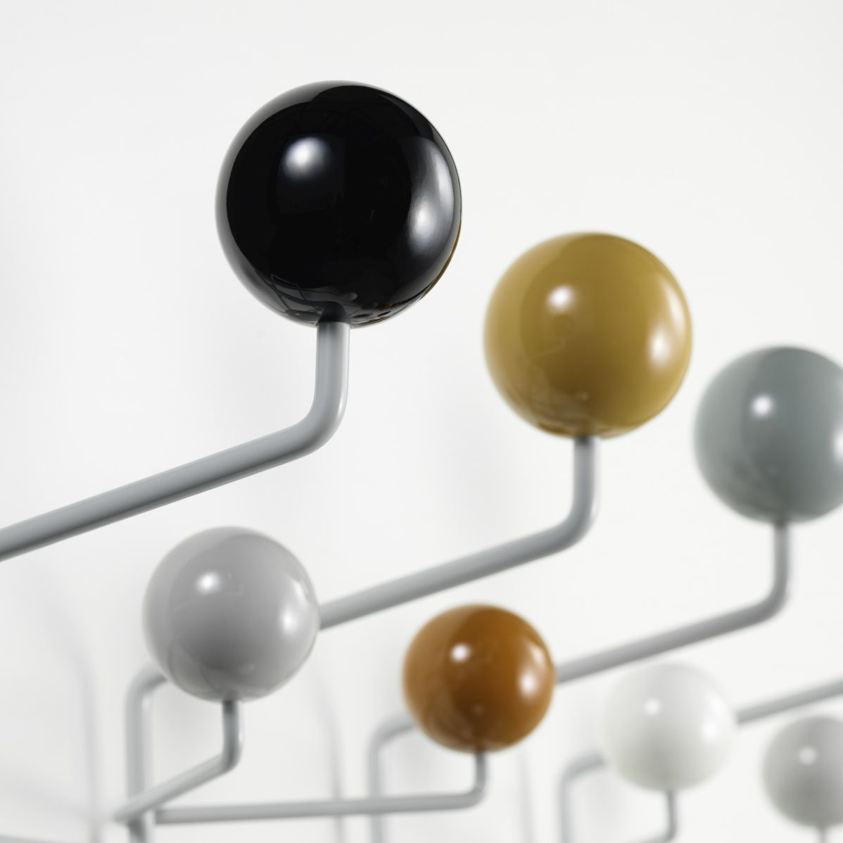 Detailaufnahme der Eames Hang it all Garderobe von Vitra in neutralen Farben mit bunten Holzkugeln.