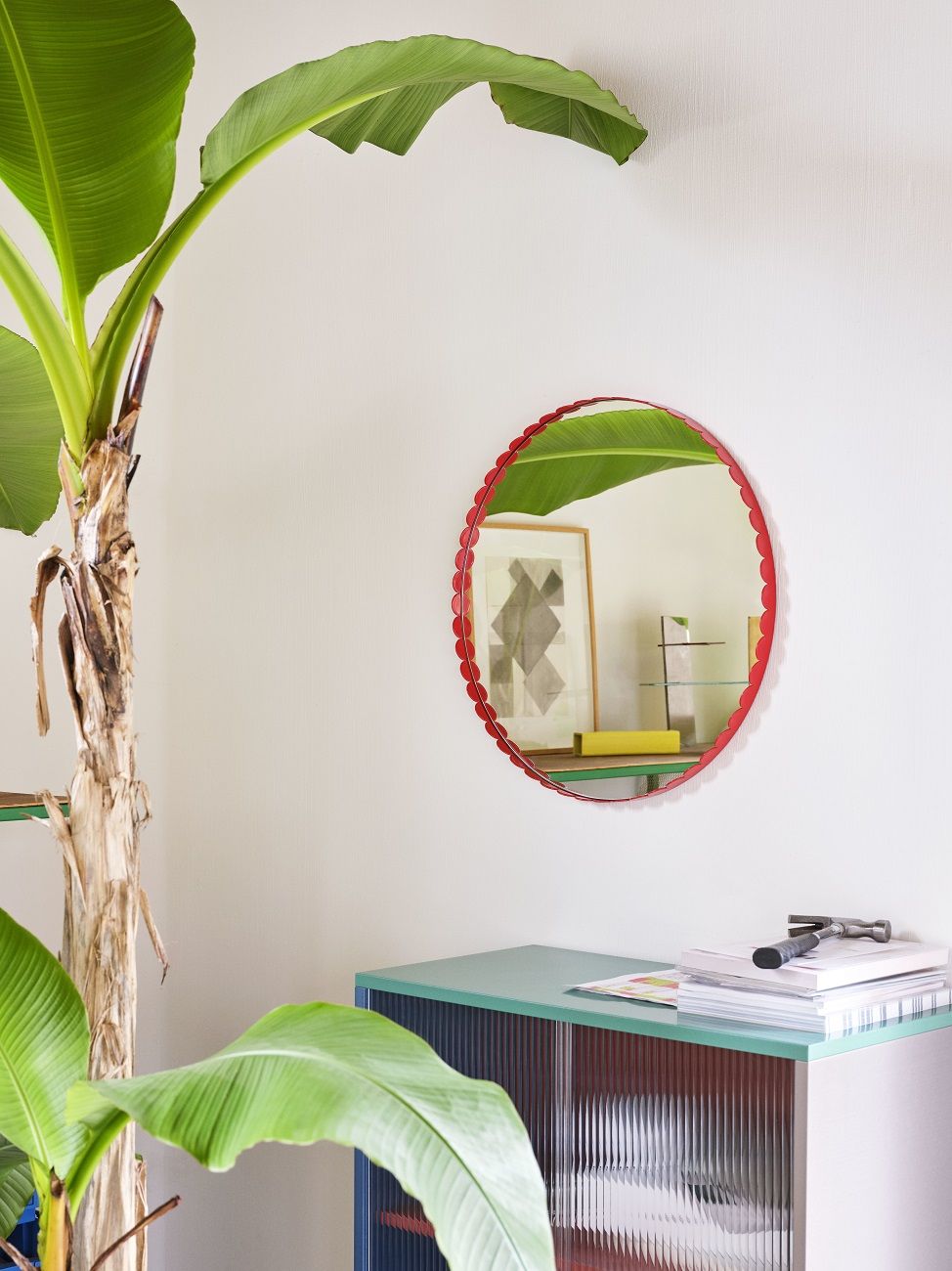 Runder Arcs Mirror Spiegel von Hay in Rot an einer weißen Wand mit Pflanze.