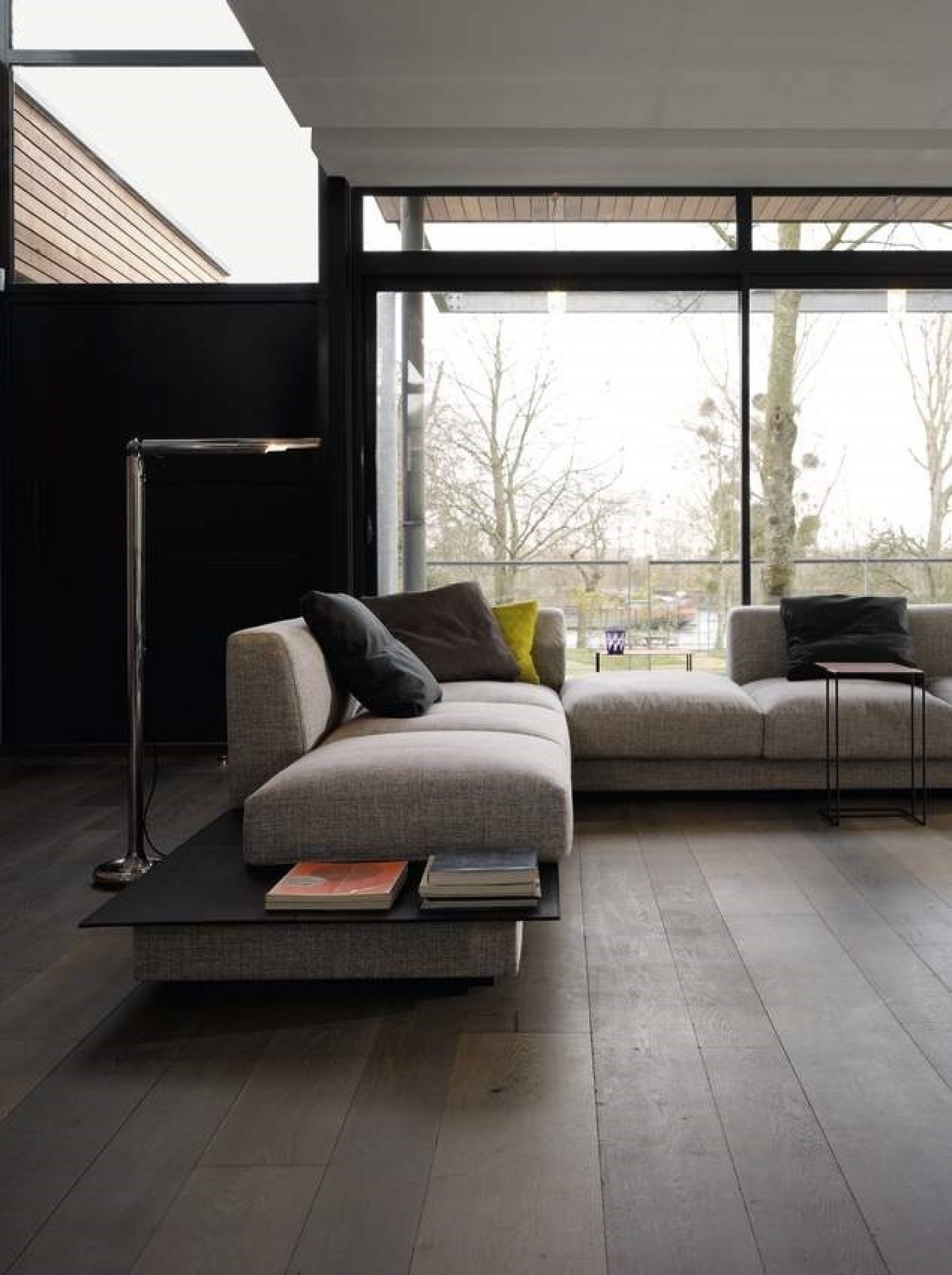 Oki Beistelltisch von Walter Knoll neben einem grauen Sofa in einem modernen Wohnzimmer.