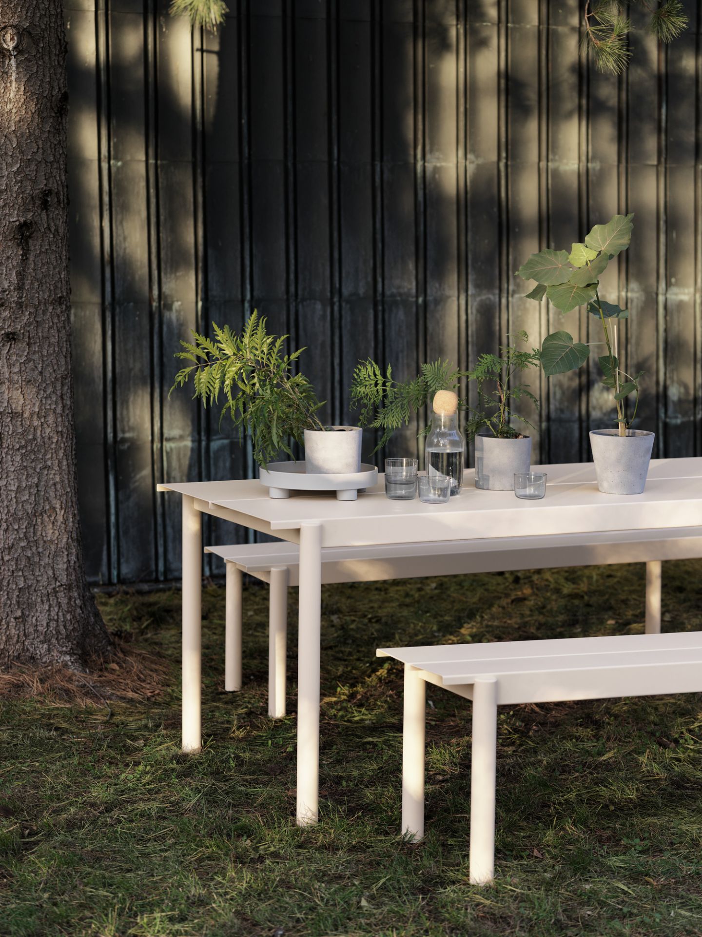 Linear Steel Table von Muuto, ein Outdoor Tisch mit Bänken im Garten.