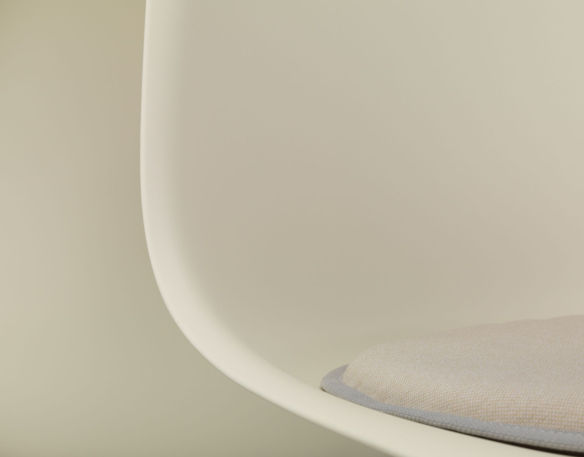 Detailaufnahme: Vitra Seat Dot Sitzkissen in Beige und Grau auf einem Stuhl.