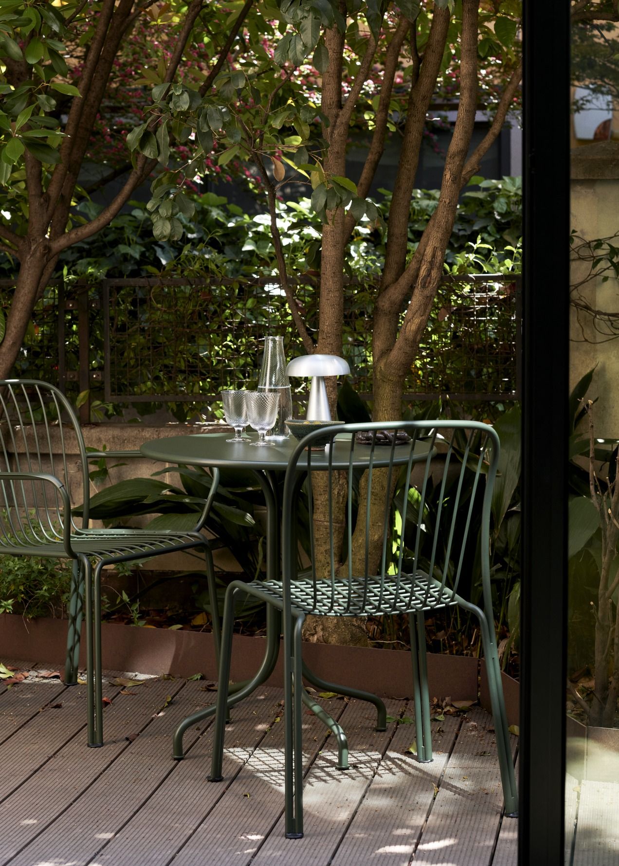 AndTradition Thorvald Stühle und Tisch im Garten, grüne Outdoor Möbel mit Armlehnen und stilvollem Design.