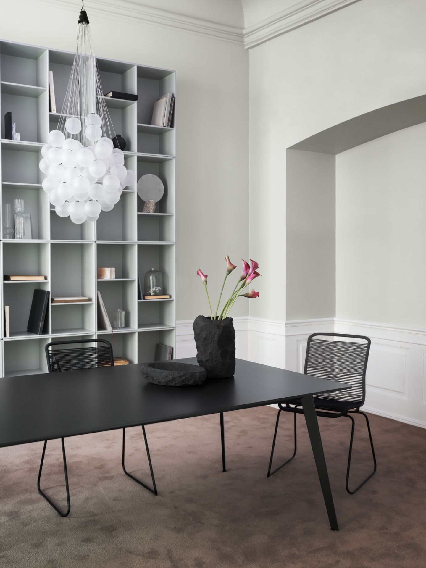 Schwarzer Esstisch mit zwei Panton One Stühlen und Dekoration in einem modernen Esszimmer.