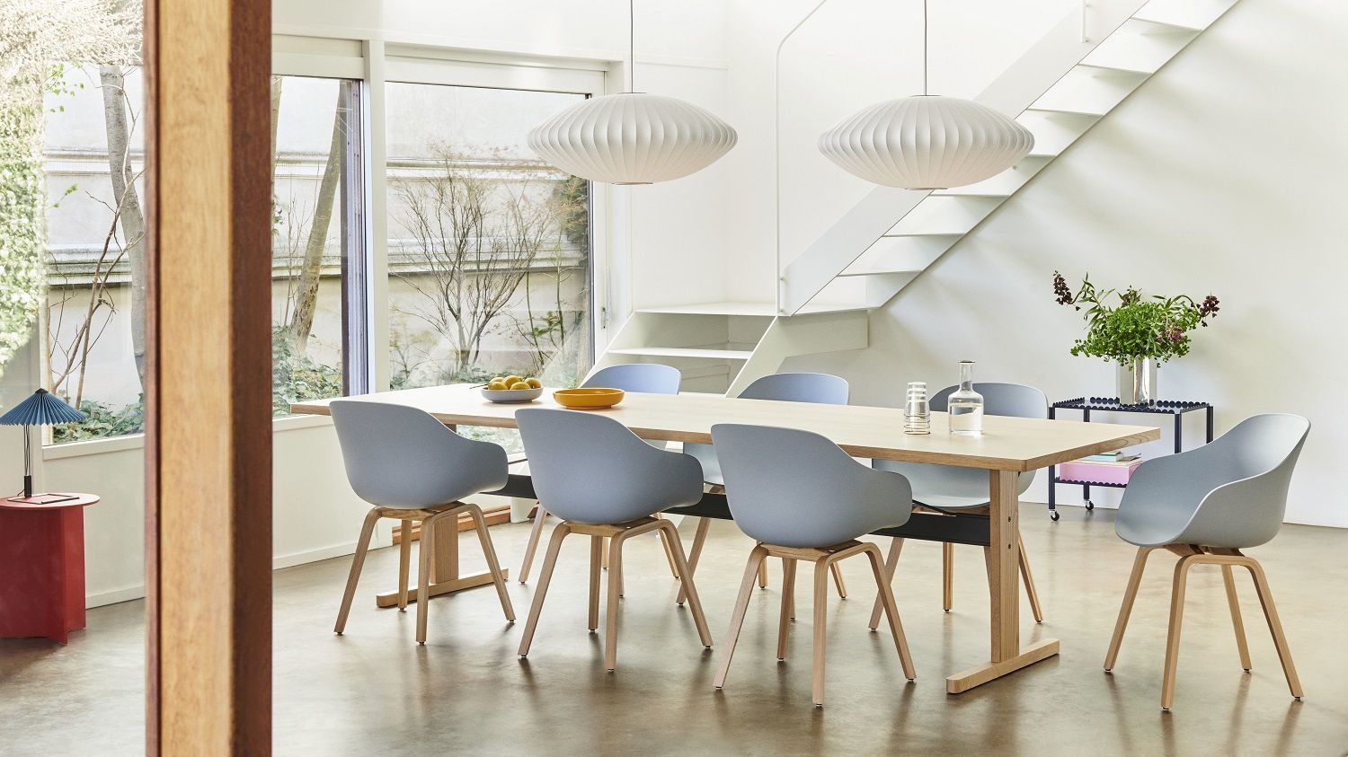 Helles Esszimmer mit Esstisch und sechs grauen About a Chair AAC222 Stühlen von Hay mit Holzbeinen.