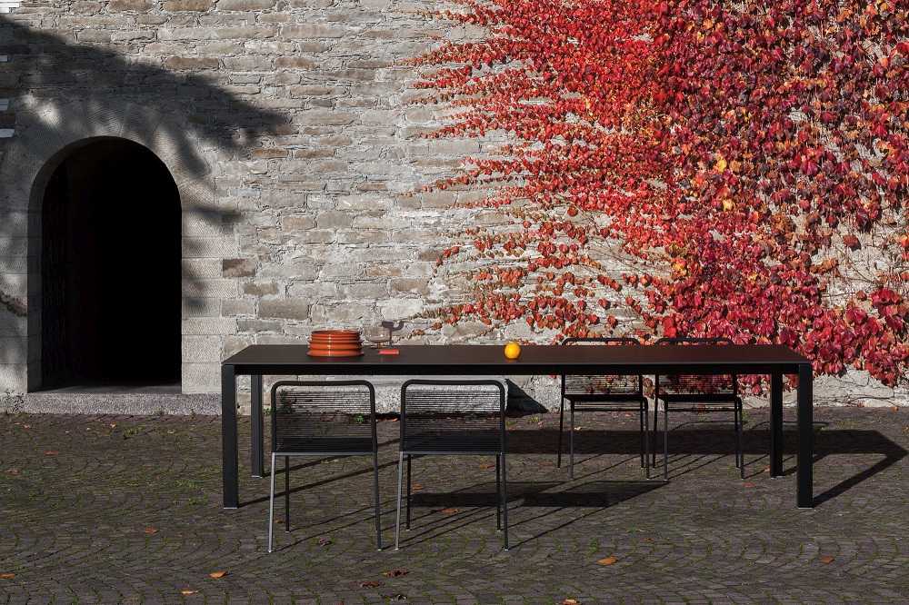 ARIA S42 Outdoor Chair Stuhl von La Palma mit Tisch und Geschirr vor Efeuwand.