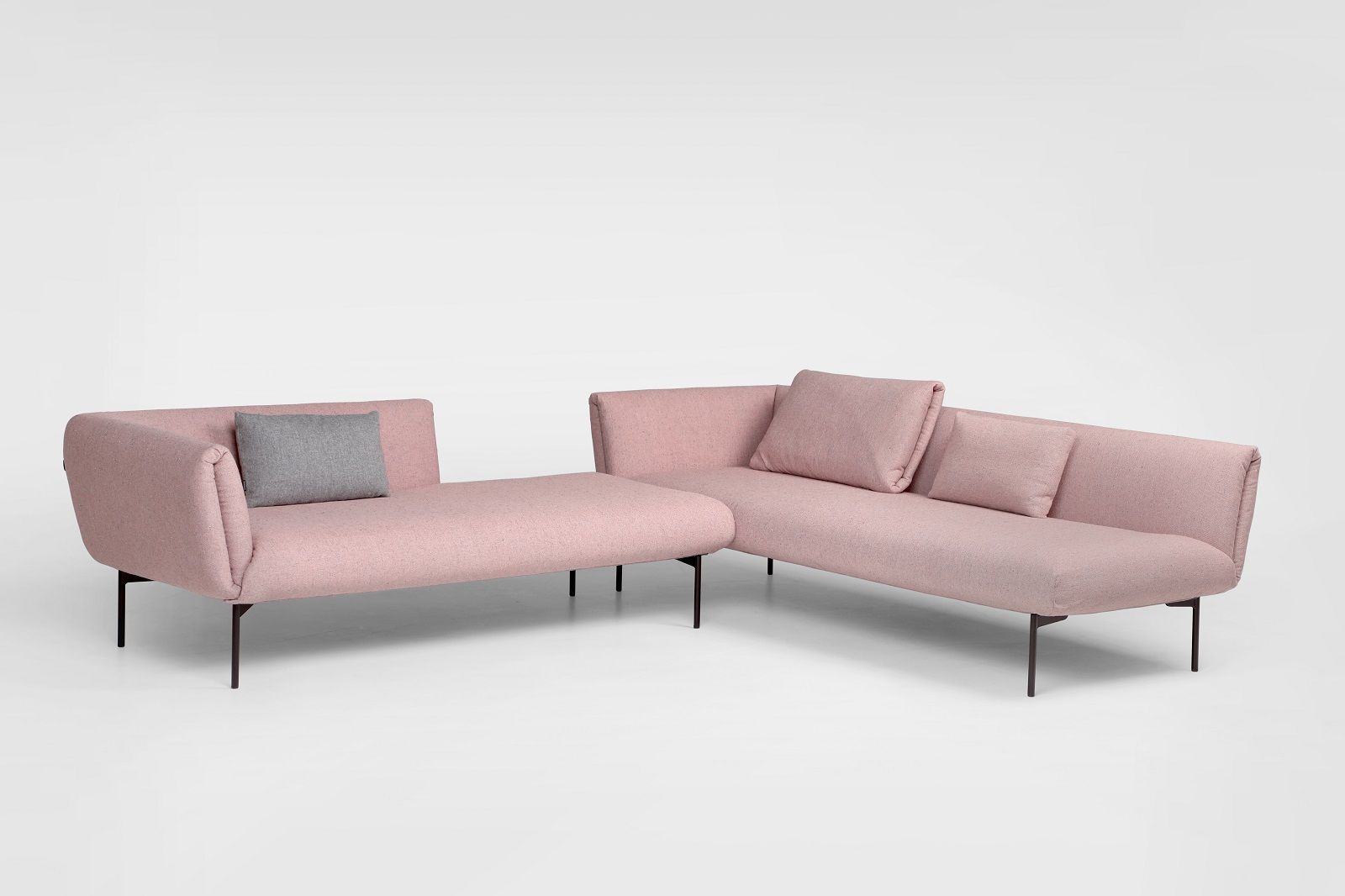 Impression modulares Sofa von Prostoria in Rosa mit schwarzen Füßen und grauen Kissen.