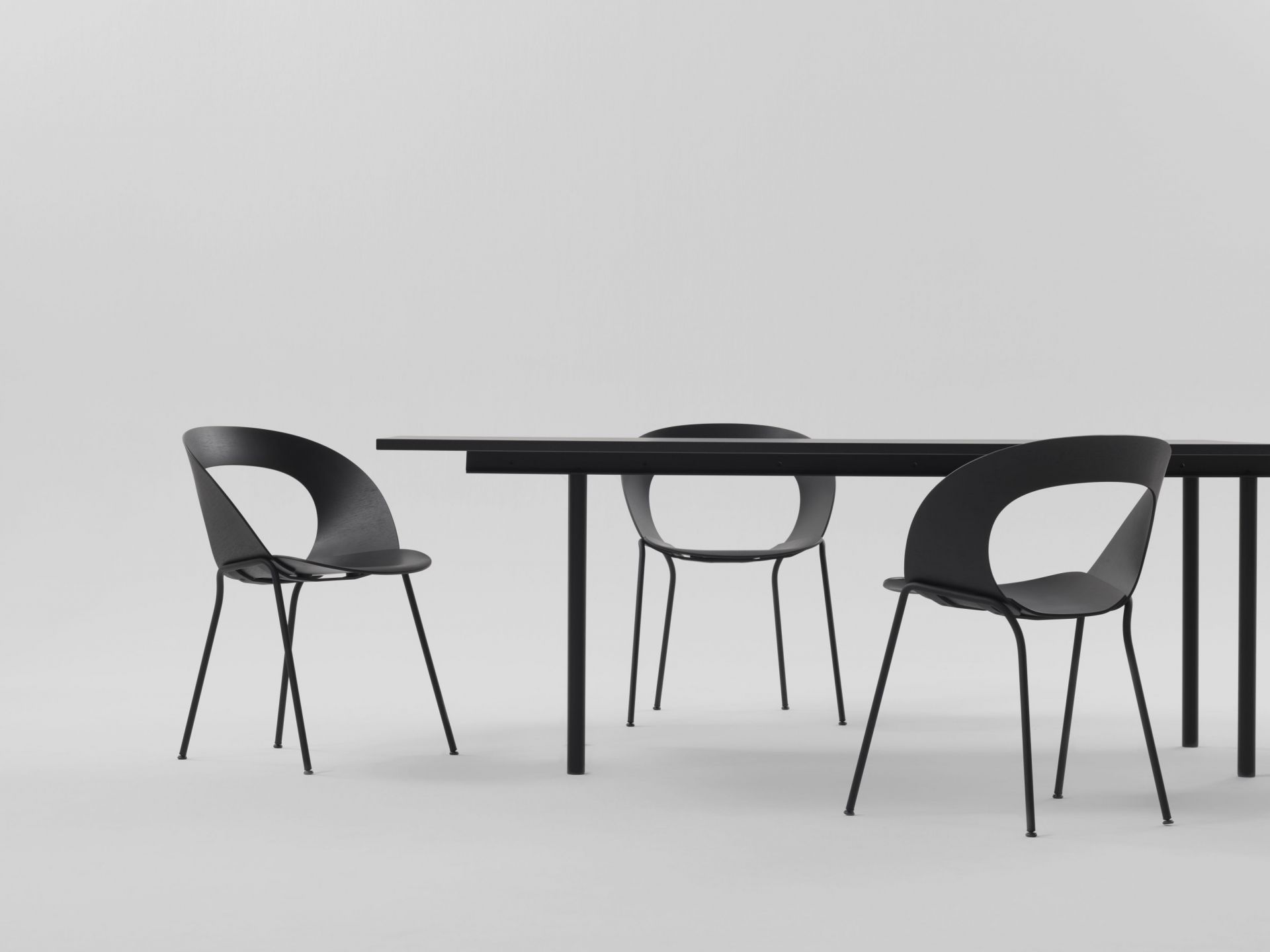 Schwarze Mudra Stühle von Brunner um einen Esstisch, minimalistisches Design für Esszimmer und Büro.