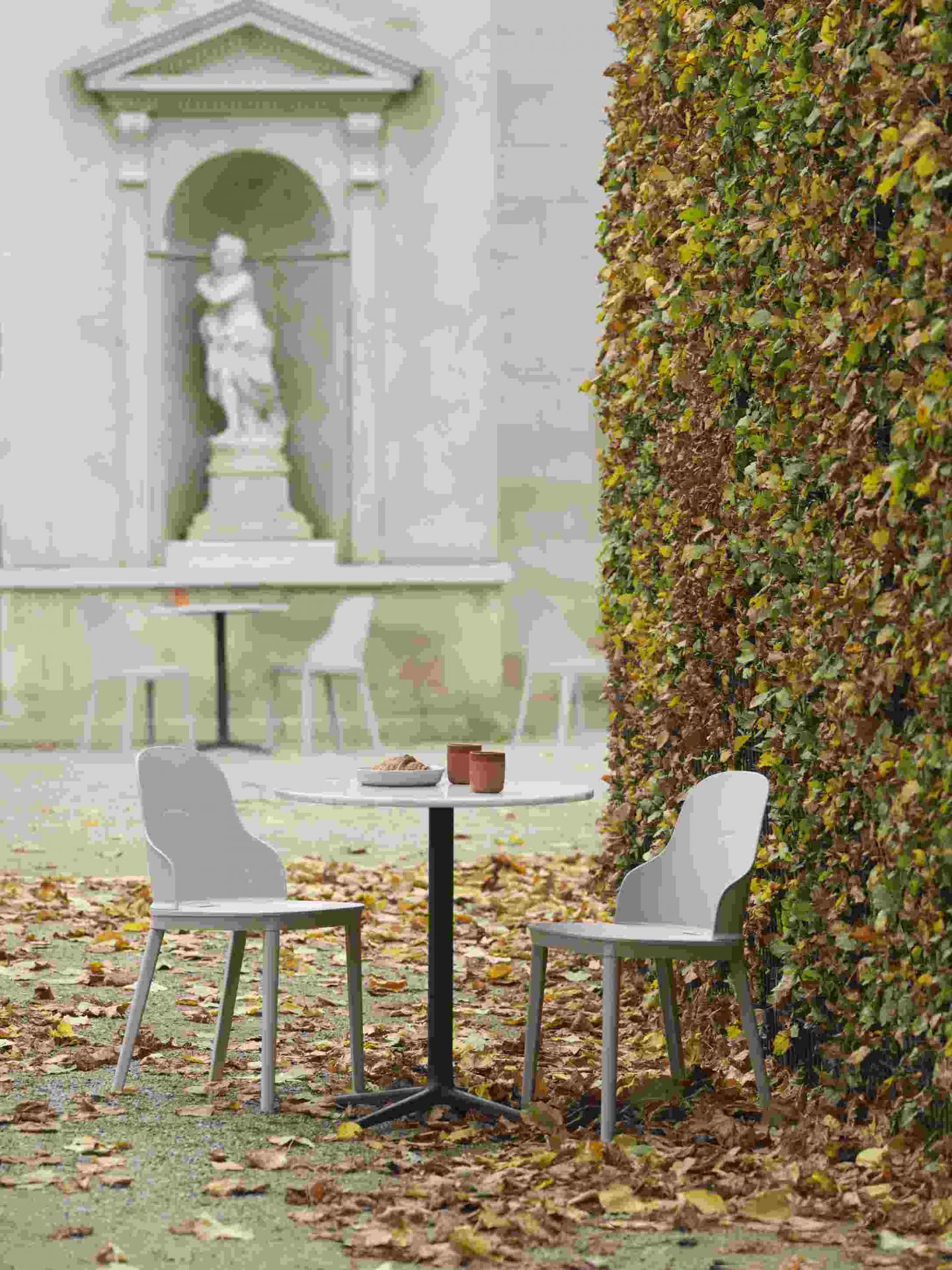 Allez Chair PP Stuhl von Normann Copenhagen in Grau, mit Tisch und Herbstlaub im Garten.