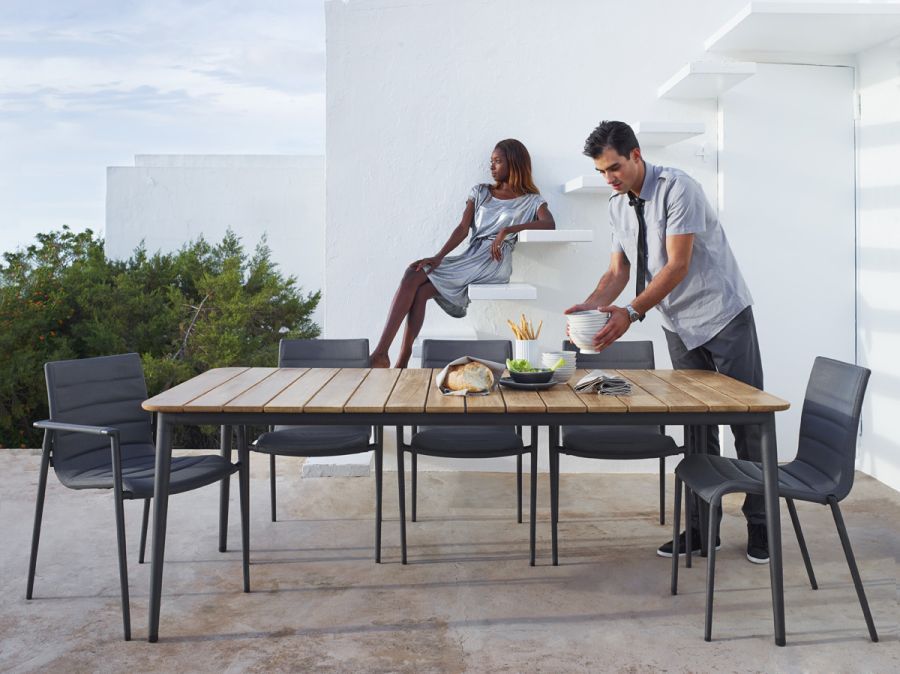 Core Outdoor Stuhl von Cane-Line am Esstisch im Freien mit Personen. Gartenmöbel.