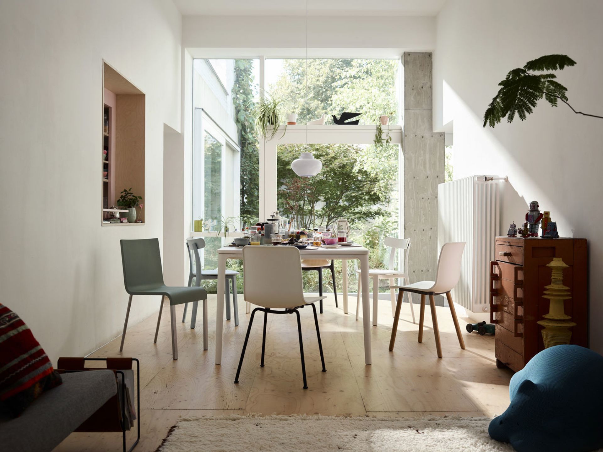 .03 Stühle von Vitra um einen Esstisch in einem hellen, modern eingerichteten Esszimmer.