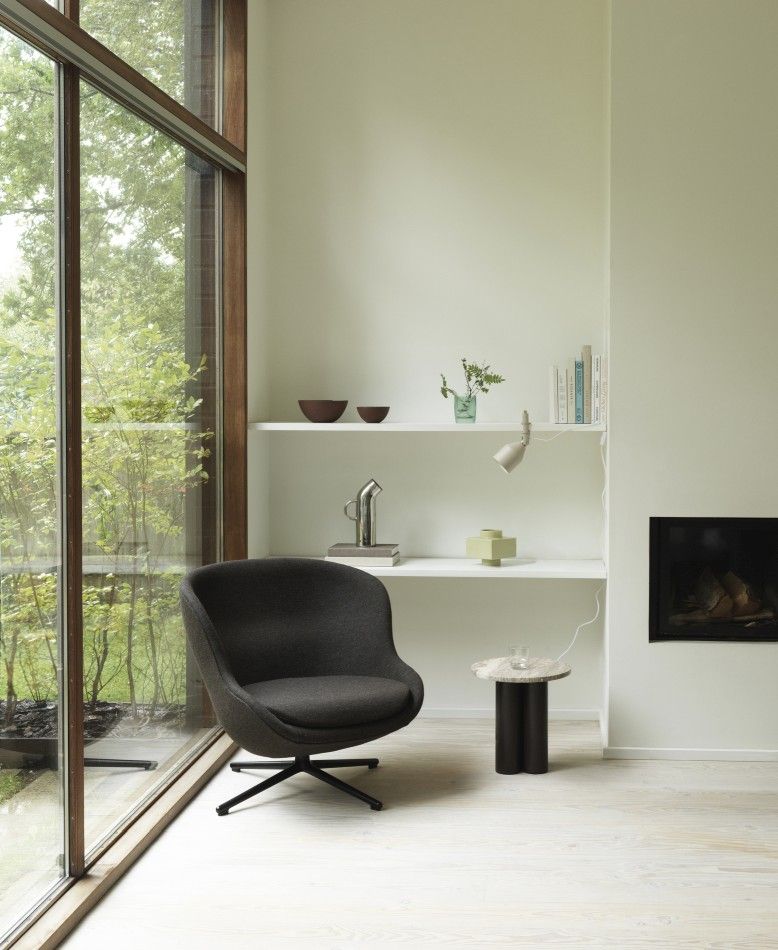 Moderner Wohnraum mit Normann Copenhagen Dit Coffee Table Beistelltisch neben Sessel und Regal.