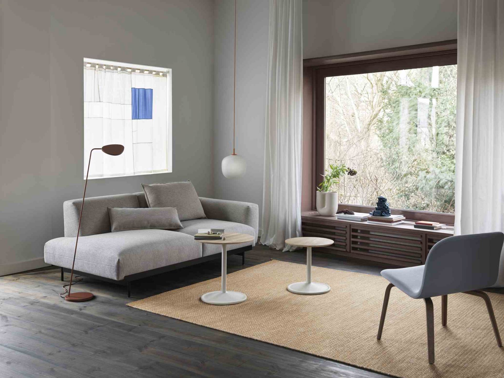 Heller Wohnraum mit Sofa, Stuhl, Lampe und zwei Muuto Soft Side Table Beistelltischen mit Holzplatte und weißem Fuß.