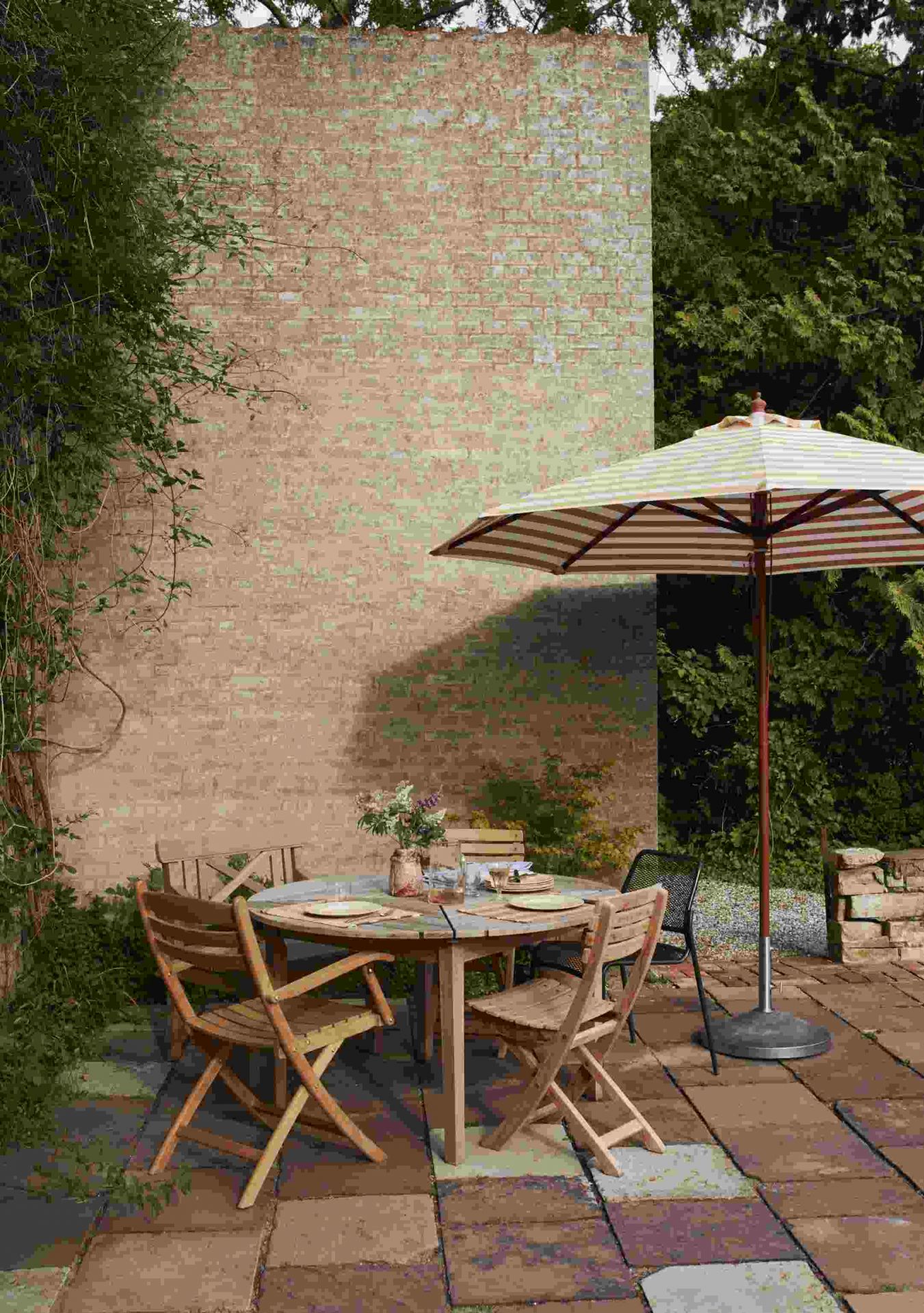 Drachmann Tisch von Skagerak by Fritz Hansen, runder Gartentisch aus Holz mit Stühlen und Sonnenschirm.