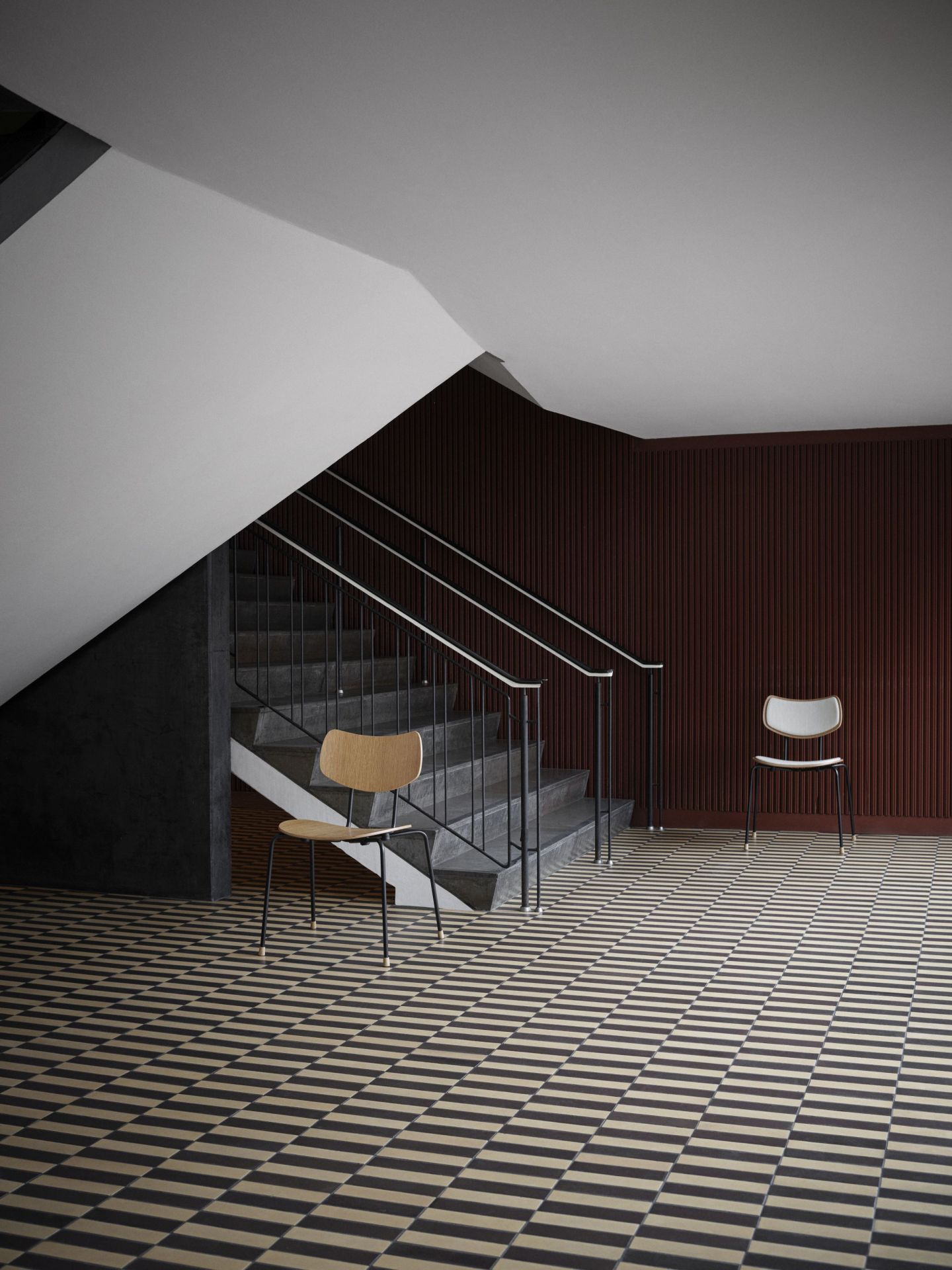Vega Chair von Carl Hansen & Søn, Holzstuhl mit Stahlbeinen vor Treppe und gemustertem Boden.