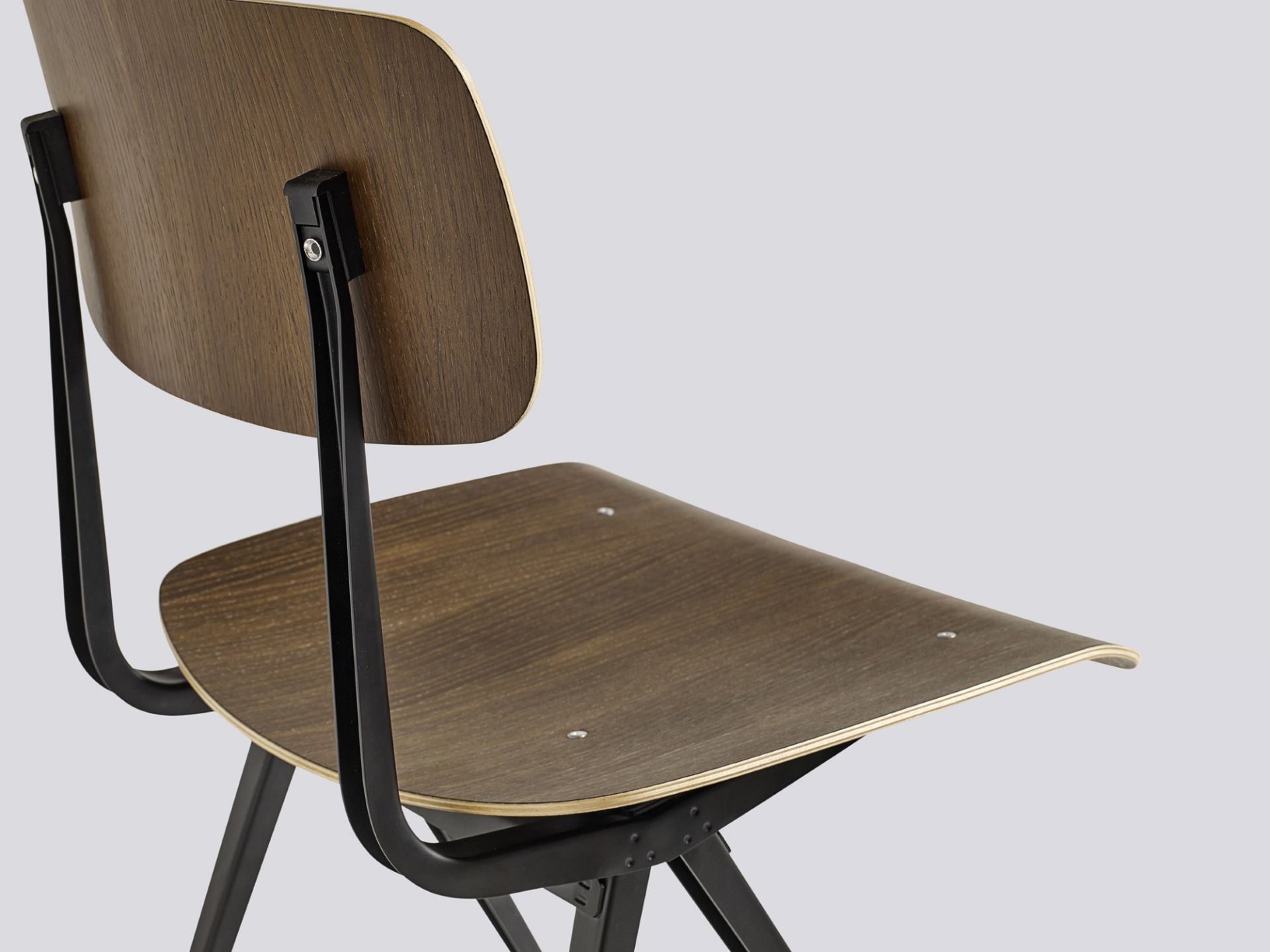 Detailaufnahme des Hay Result Chair Stuhls mit dunklem Holzfurnier und schwarzem Stahlgestell, Designklassiker für Esszimmer und Büro.